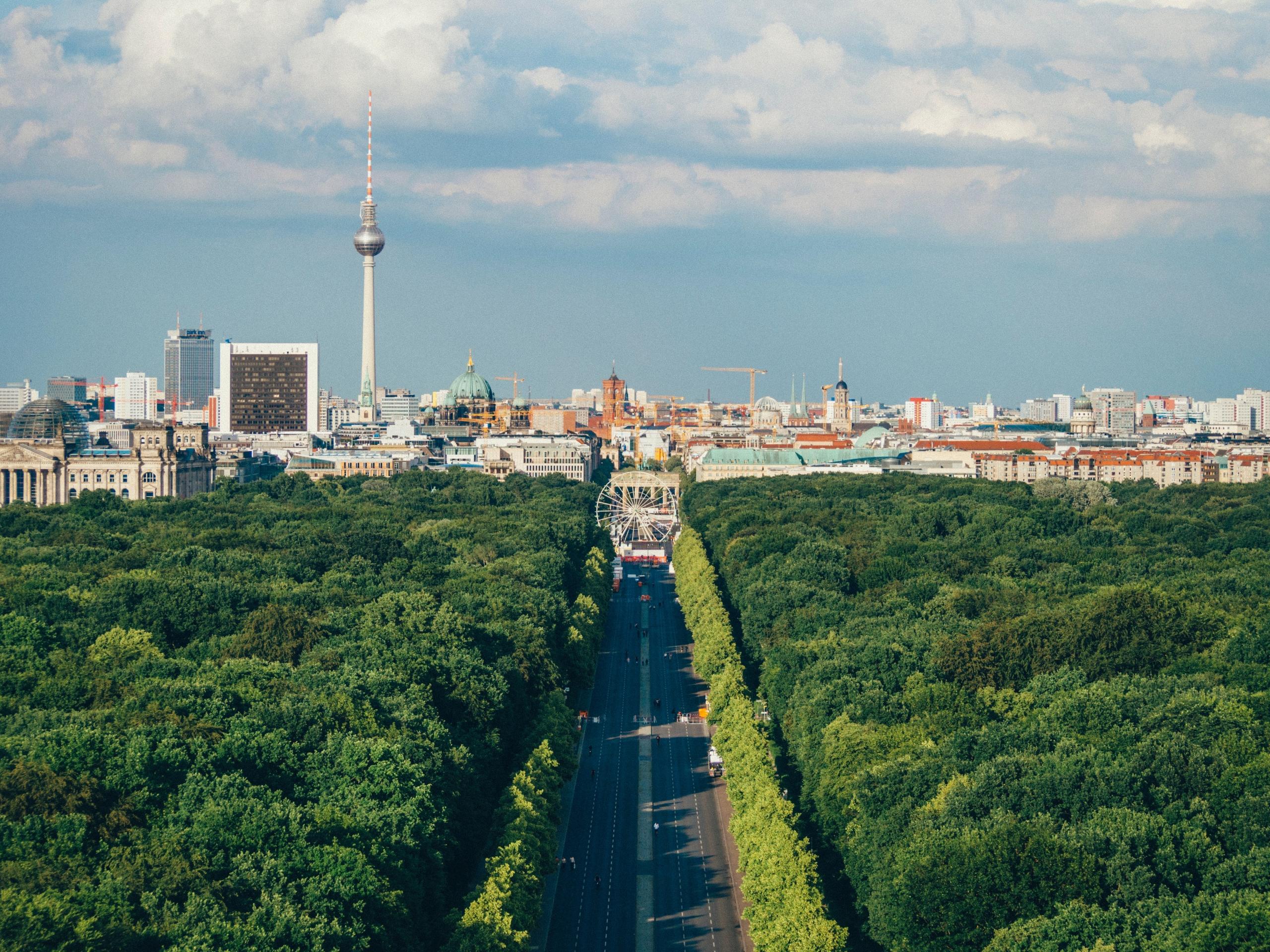 Über den Tiergarten hinweg schaut man auf das Brandenburger Tor und dahinter erhebt sich der Fernsehturm.