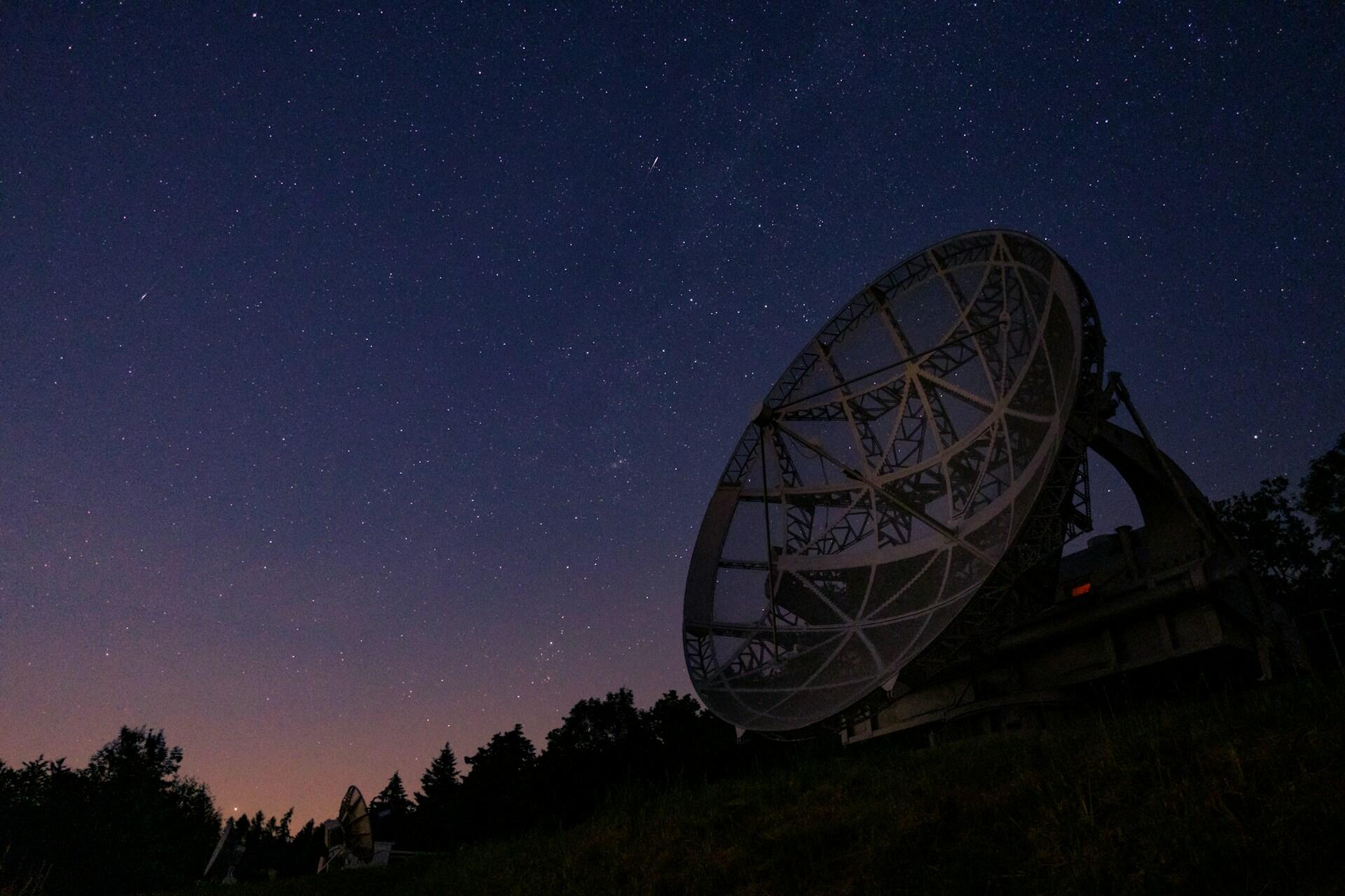 Großes Teleskop vor dunklem Sternenhimmel.