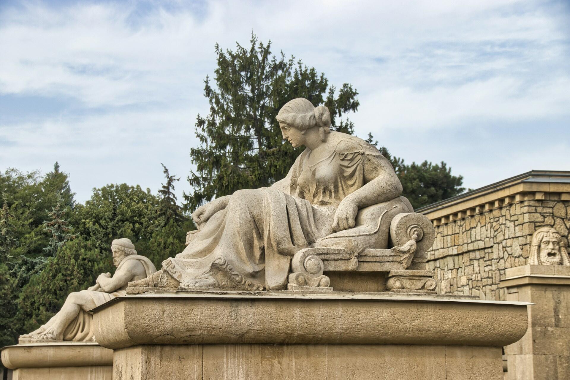 Statue von Frau auf Sockel.