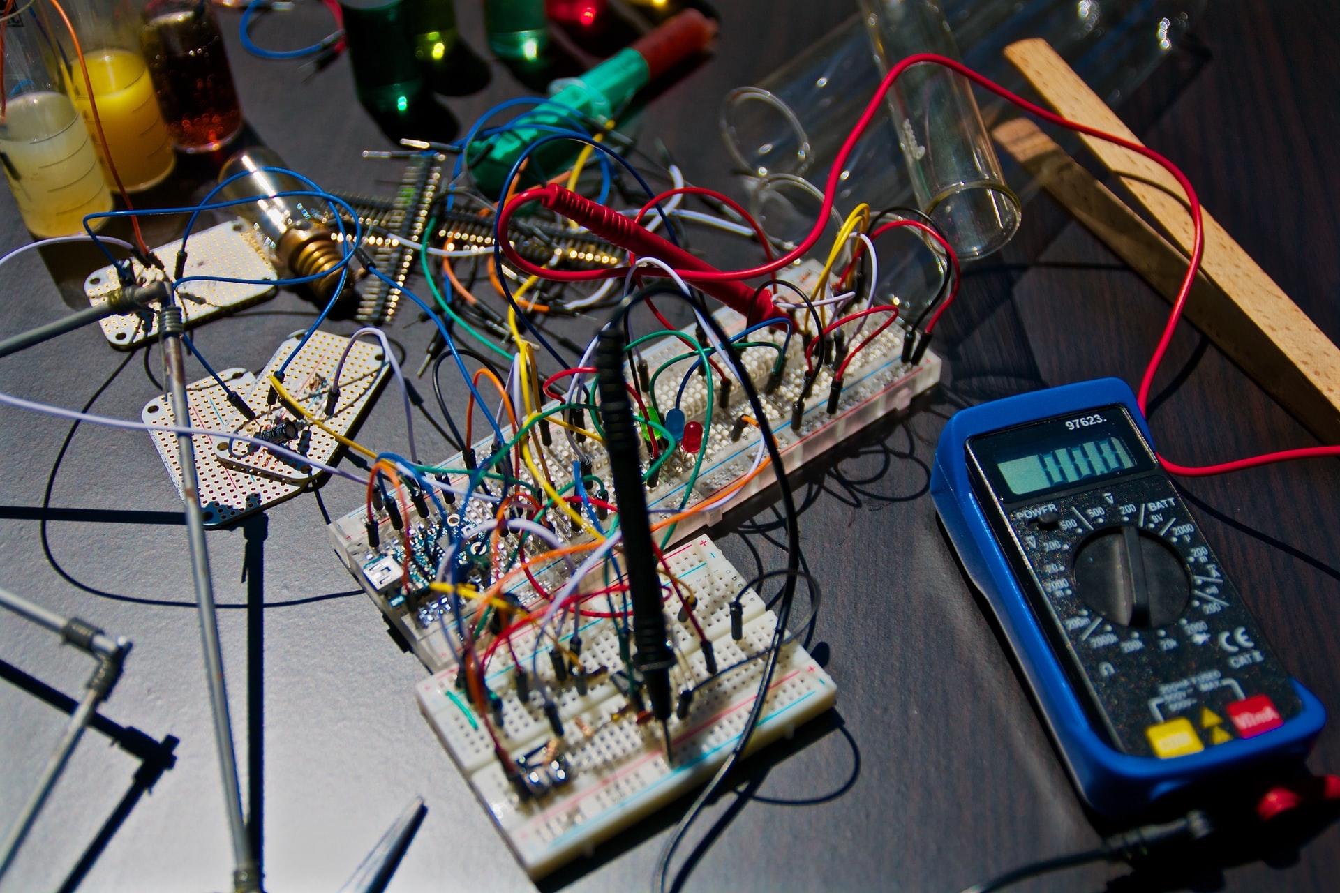 Auf einem schwarzen Tisch liegen Kabel und Elektrogeräte.