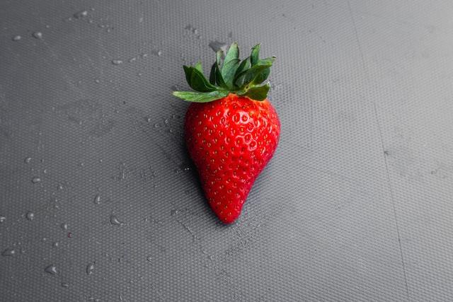 Erdbeeren wie diese auf grauem Hintergrund liegende gehören bei der Turnieren im All England Club einfach dazu!