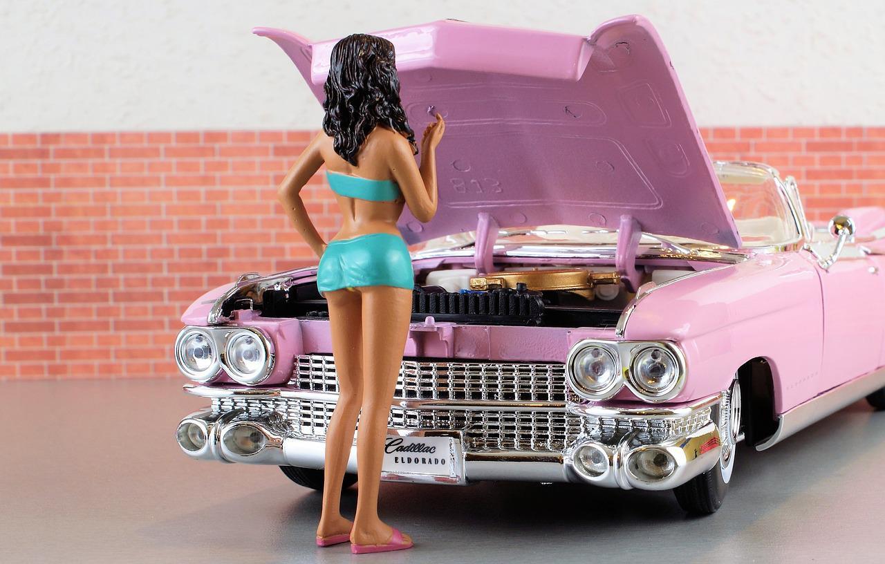 Pinkfarbenes Spielzeugauto mit Barbie davor