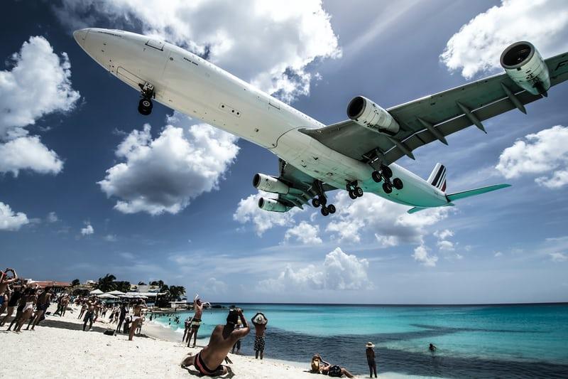 Ein Flugzeug in geringer Höhe über einem Strand in Saint-Martin.