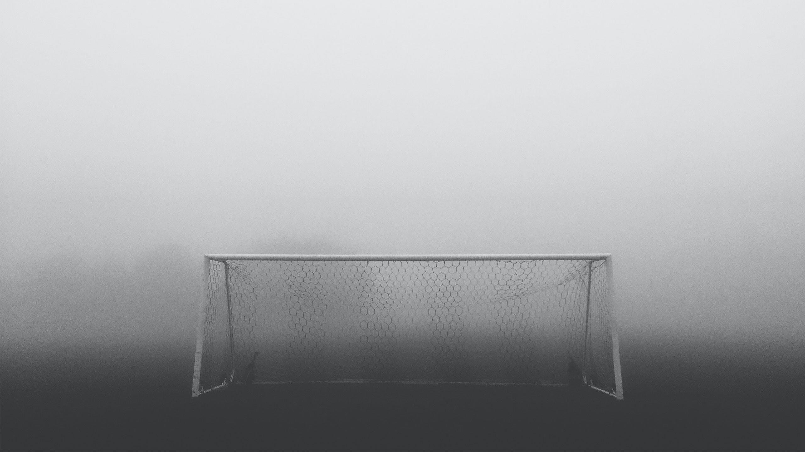Ein Fußballtor steht im Nebel.