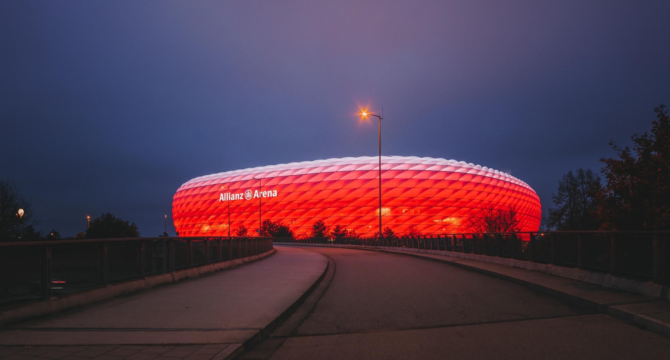 Die rot leuchtende Allianz Arena bei nacht von außen.