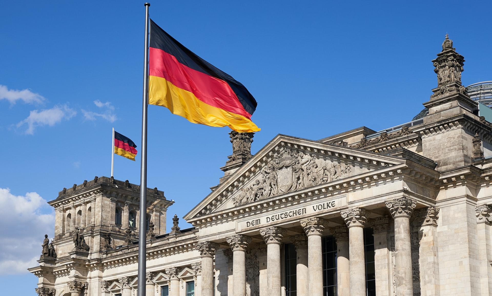 Vor dem Bundestag in Berlin weht bei strahlend blauem Himmel eine Deutschlandfahne im Wind