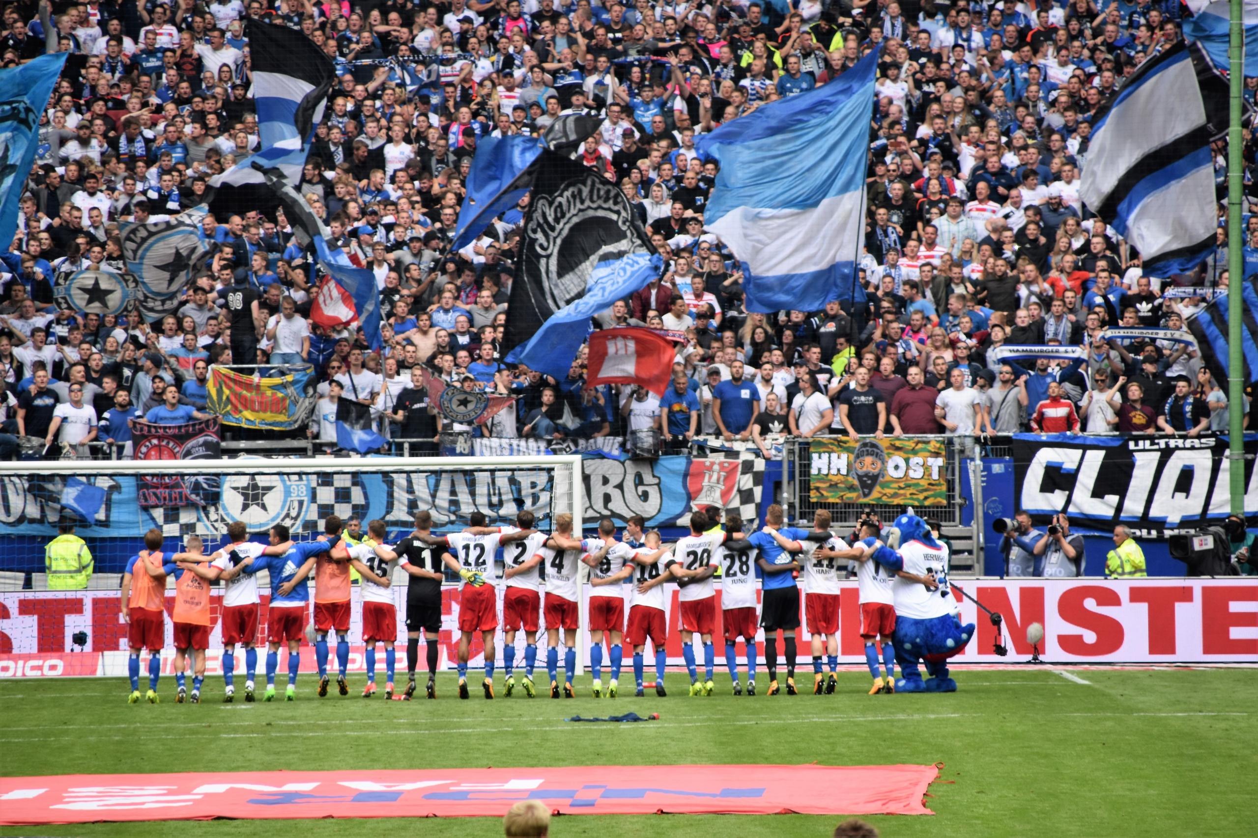 Die Mannschaft des Hamburger SV steht nach einem Spiel geschlossen vor der Fankurve. Trotz des schmerzhaften Abstiegs in der Saison 2017/18 bleibt der Club einer der traditionsreichsten Vereine der Liga.