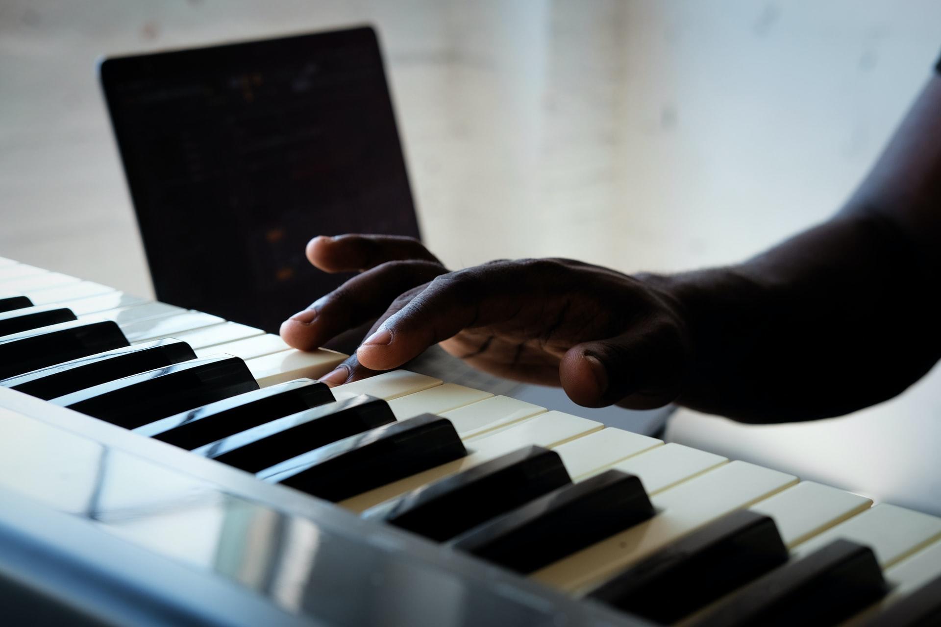 Mit einem einzelnen Finger wird eine Taste eines Keyboards heruntergedrückt.