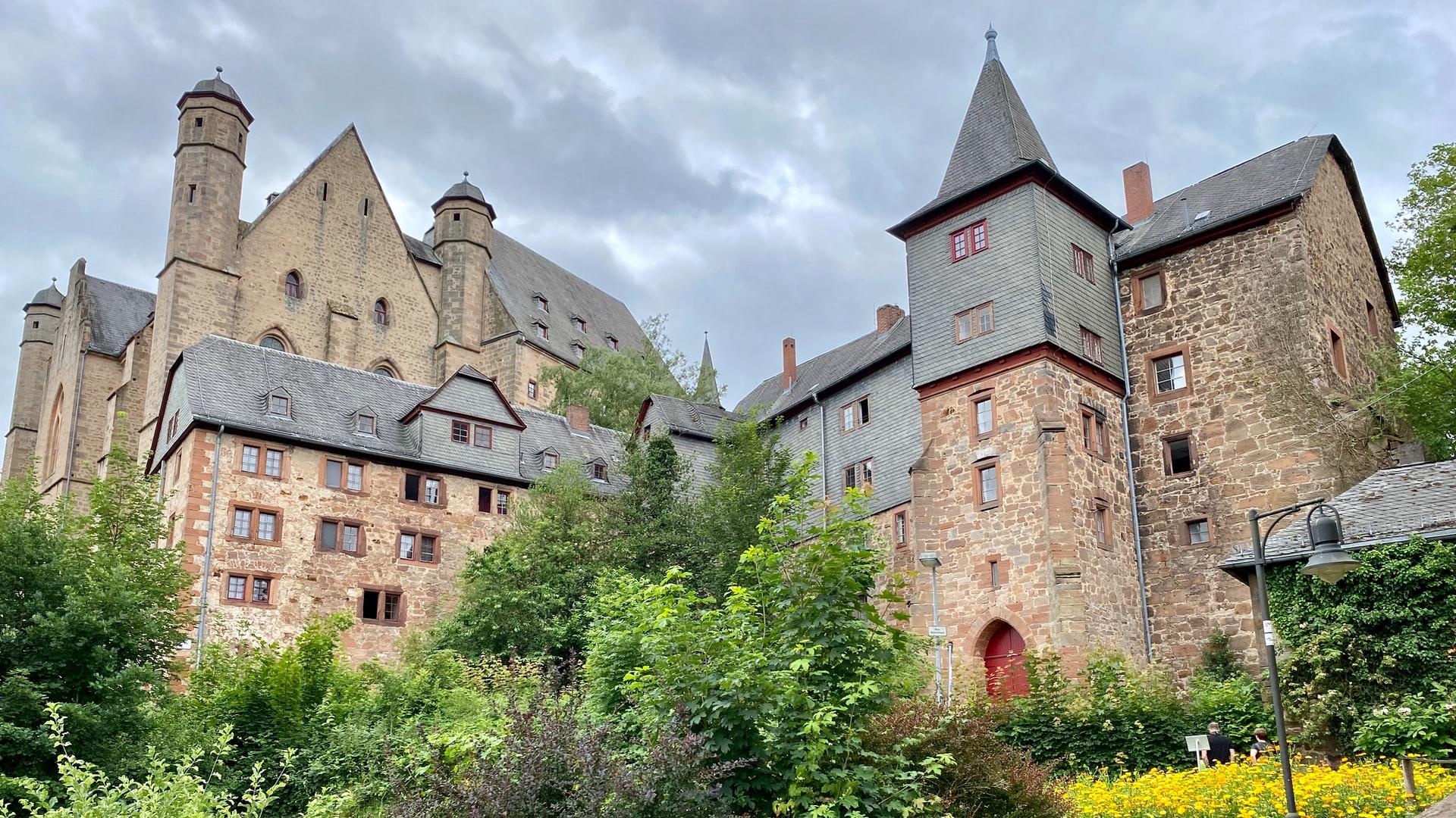 Das alte Schloss aus Backstein in Marburg vor bewölktem Himmel