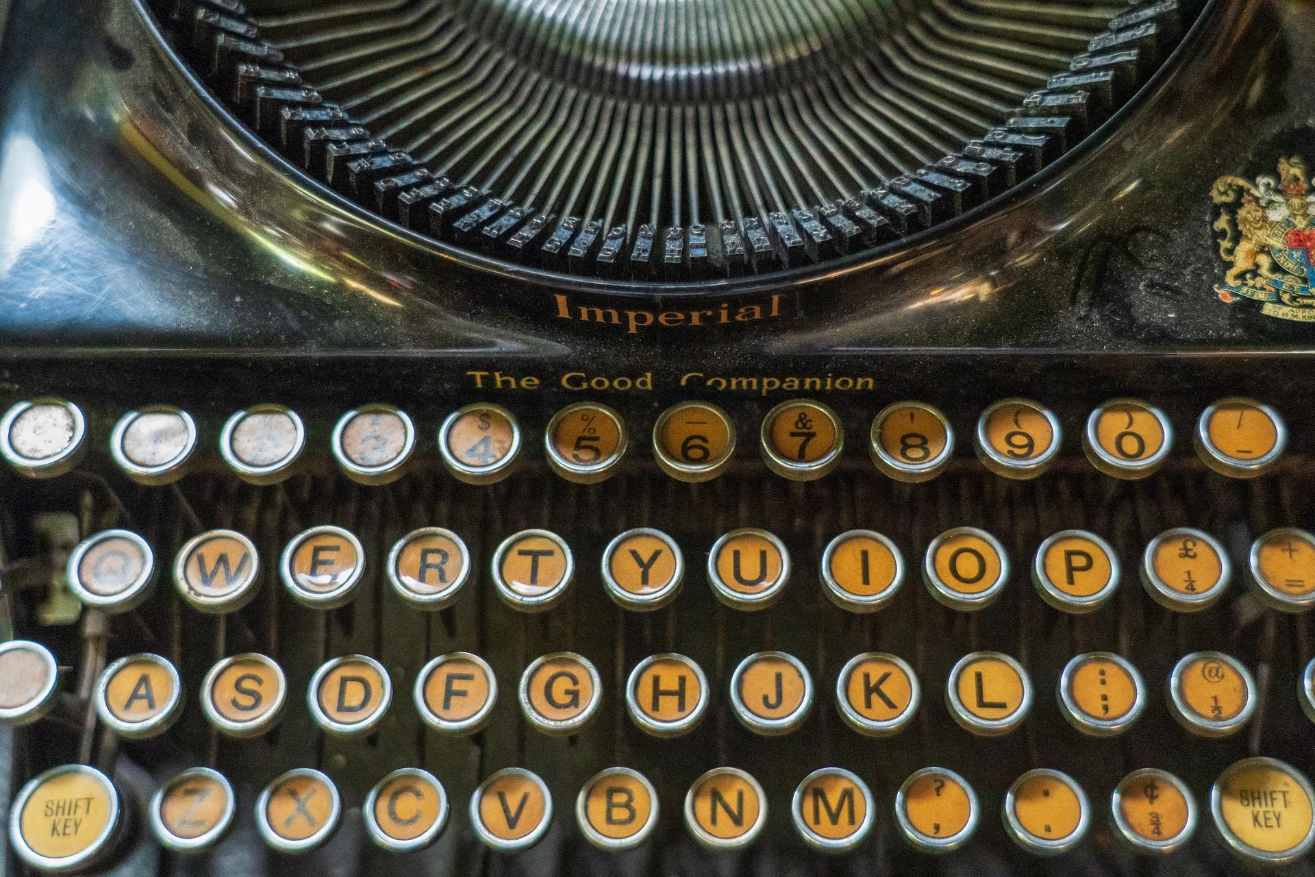 Die Nahaufnahme einer Schreibmaschine zeigt eine QWERTY-Tastatur mit runden Tasten.