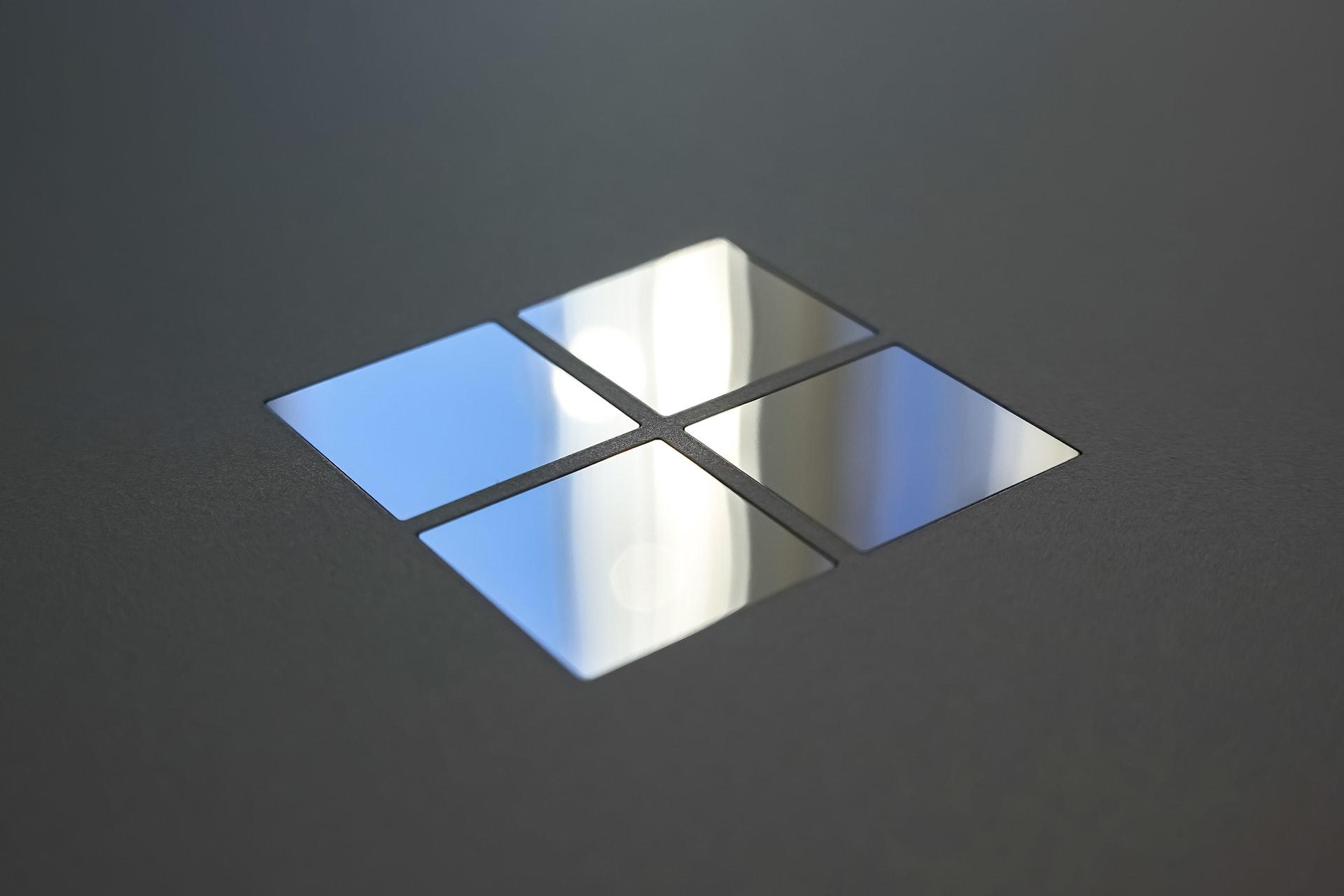 Das Logo von Microsoft erstrahlt metallisch auf schwarzem Hintergrund.