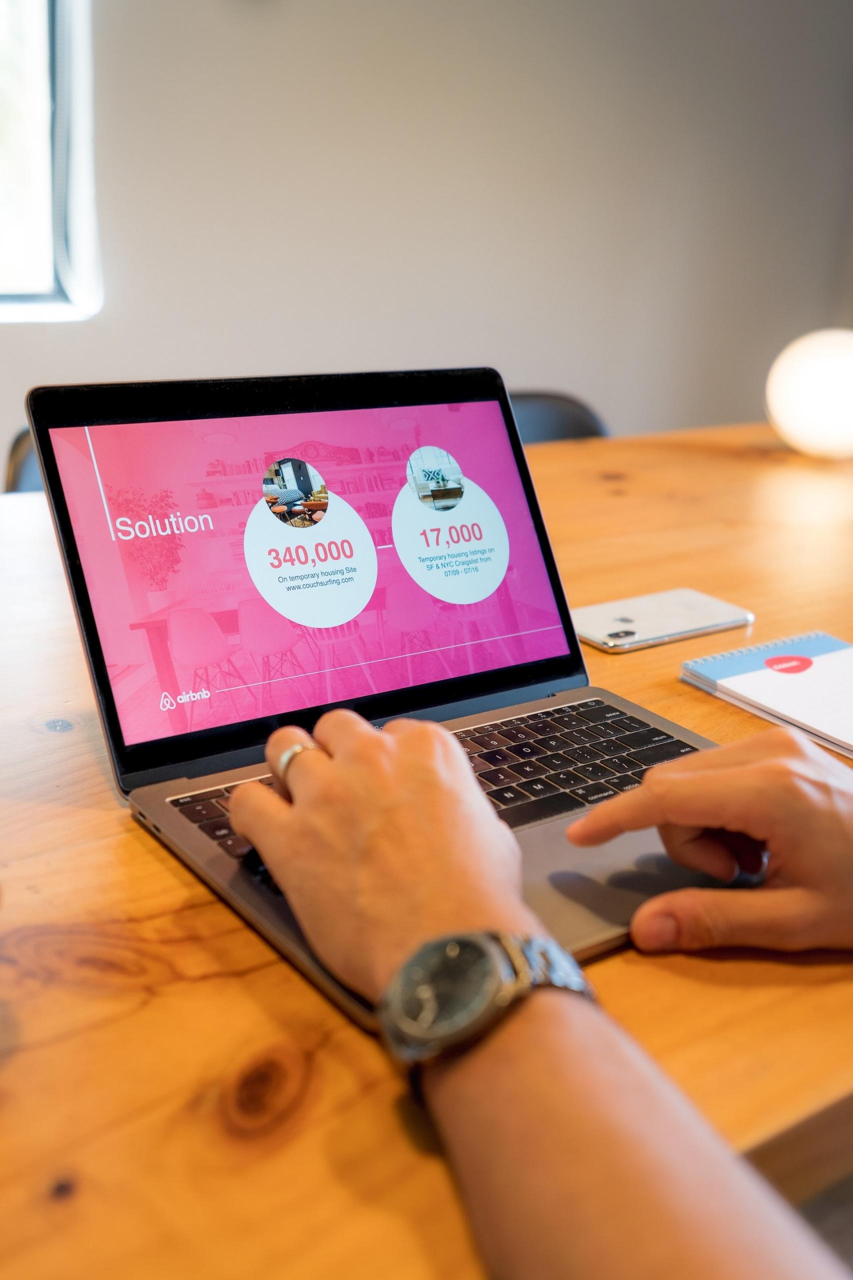 Auf einem Tisch steht ein Laptop, auf dessen Bildschirm sieht man das Wort 