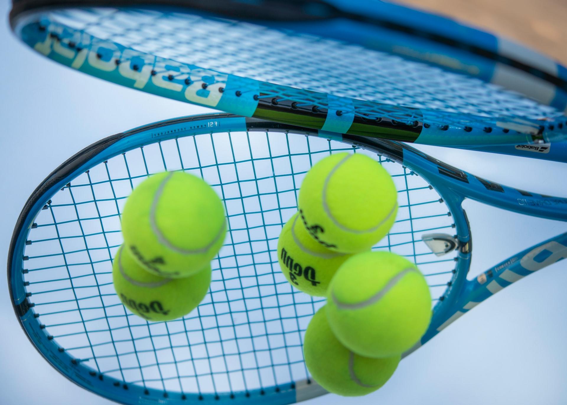 Nahaufnahme von Tennisbällen zwischen Tennisschlägern