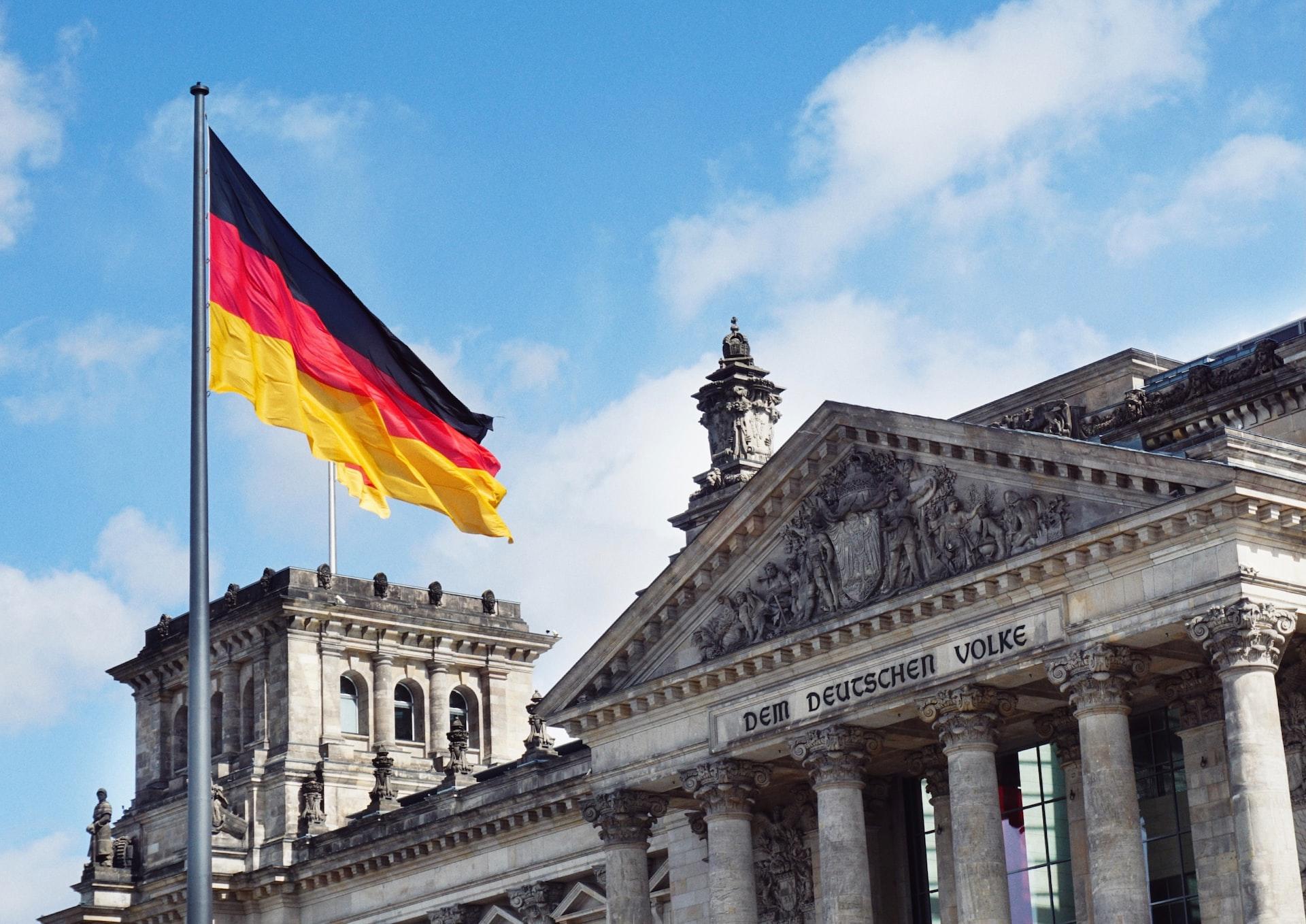 Eine deutsche Flagge weht vor dem Reichstagsgebäude in Berlin.