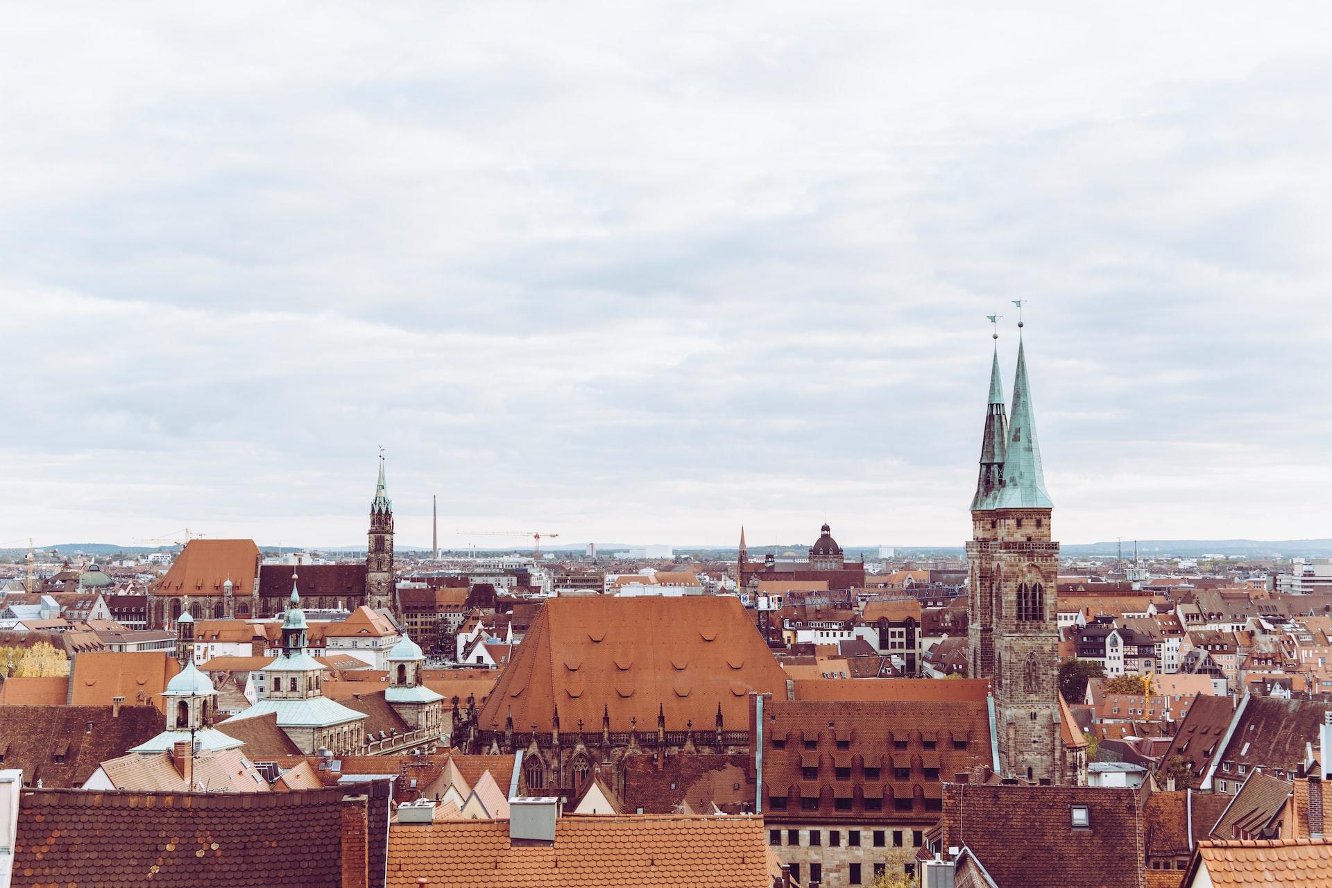 Ansicht auf Nürnberg mit Kirche und Dächern von Häusern von oben.