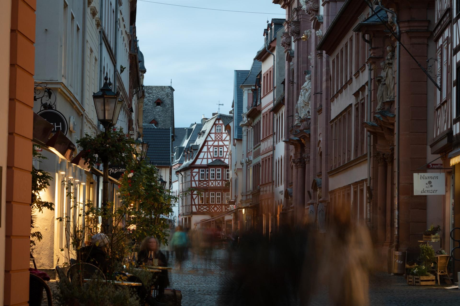 Menschen laufen verschwommen durch die Altstadt von Mainz.