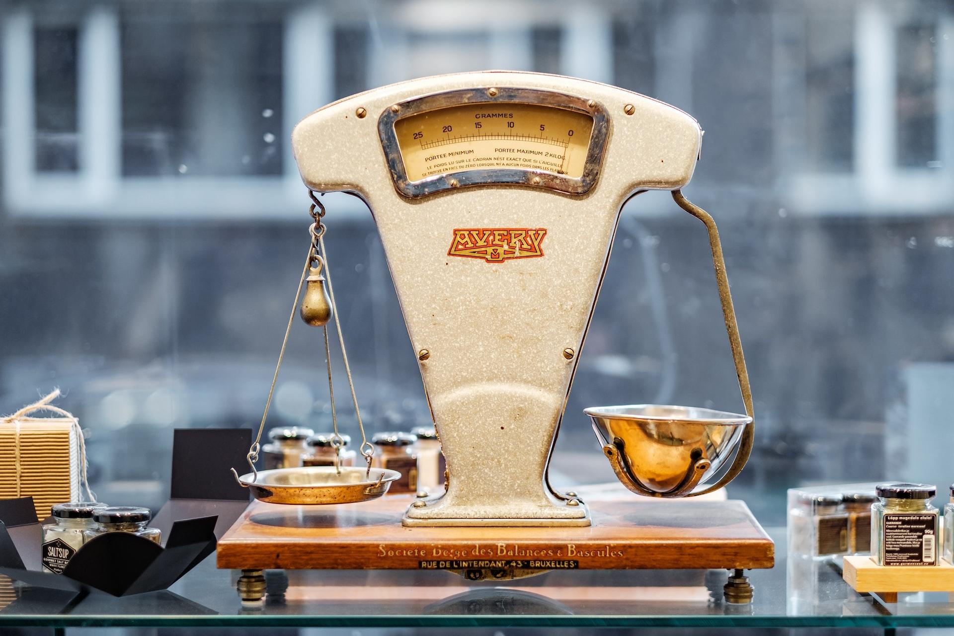 Eine alte Waage mit Gewichten steht im Schaufenster. 
