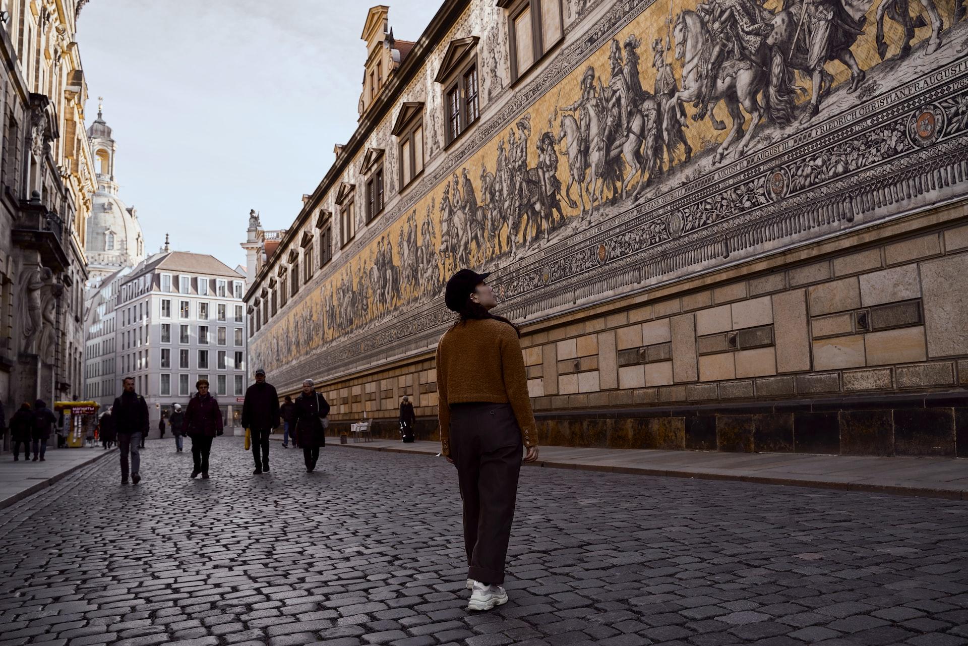 Eine Person steht vor einem historischen Gebäude in Dresden.