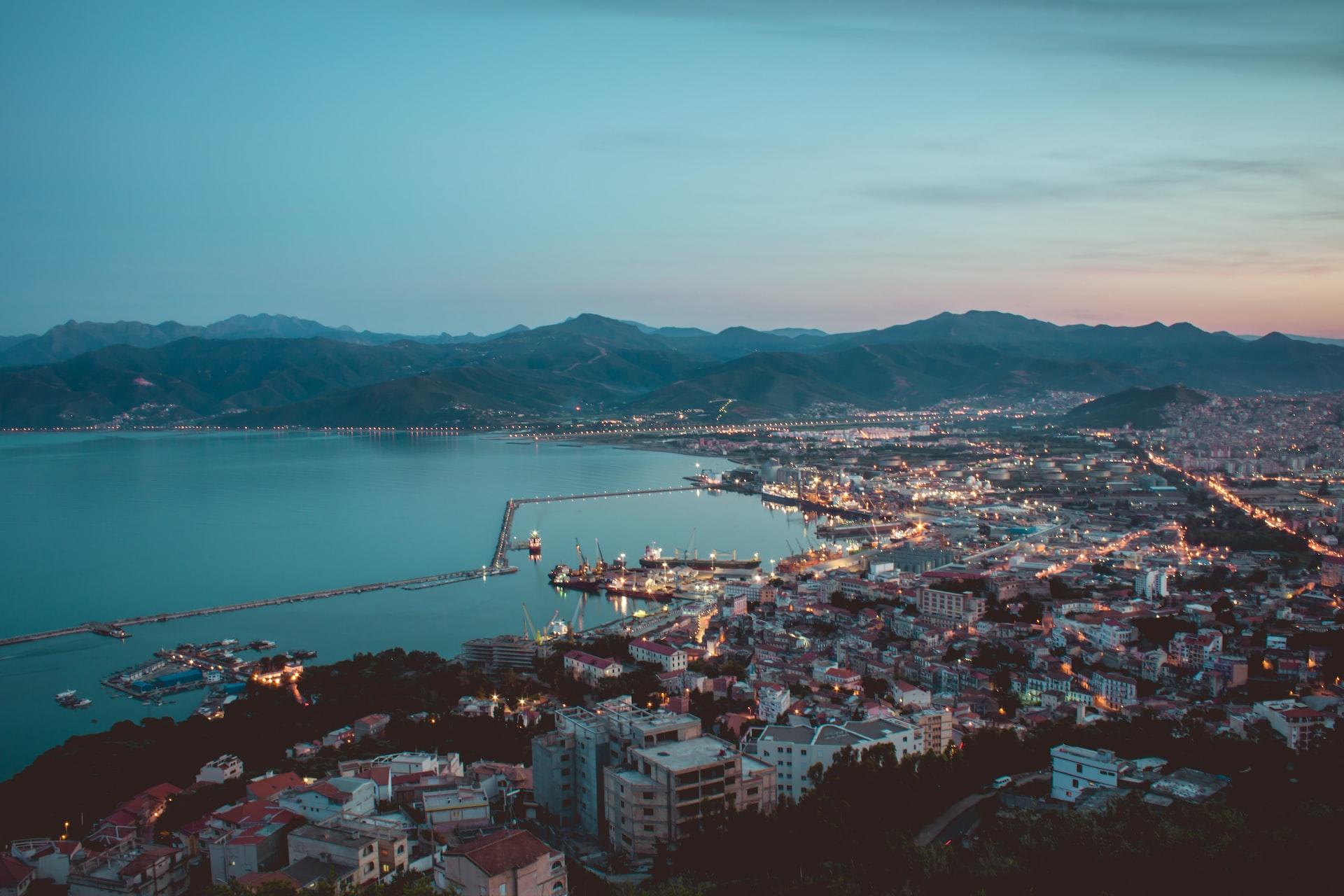 Blick auf eine Stadt am Meer in der Dämmerung. 