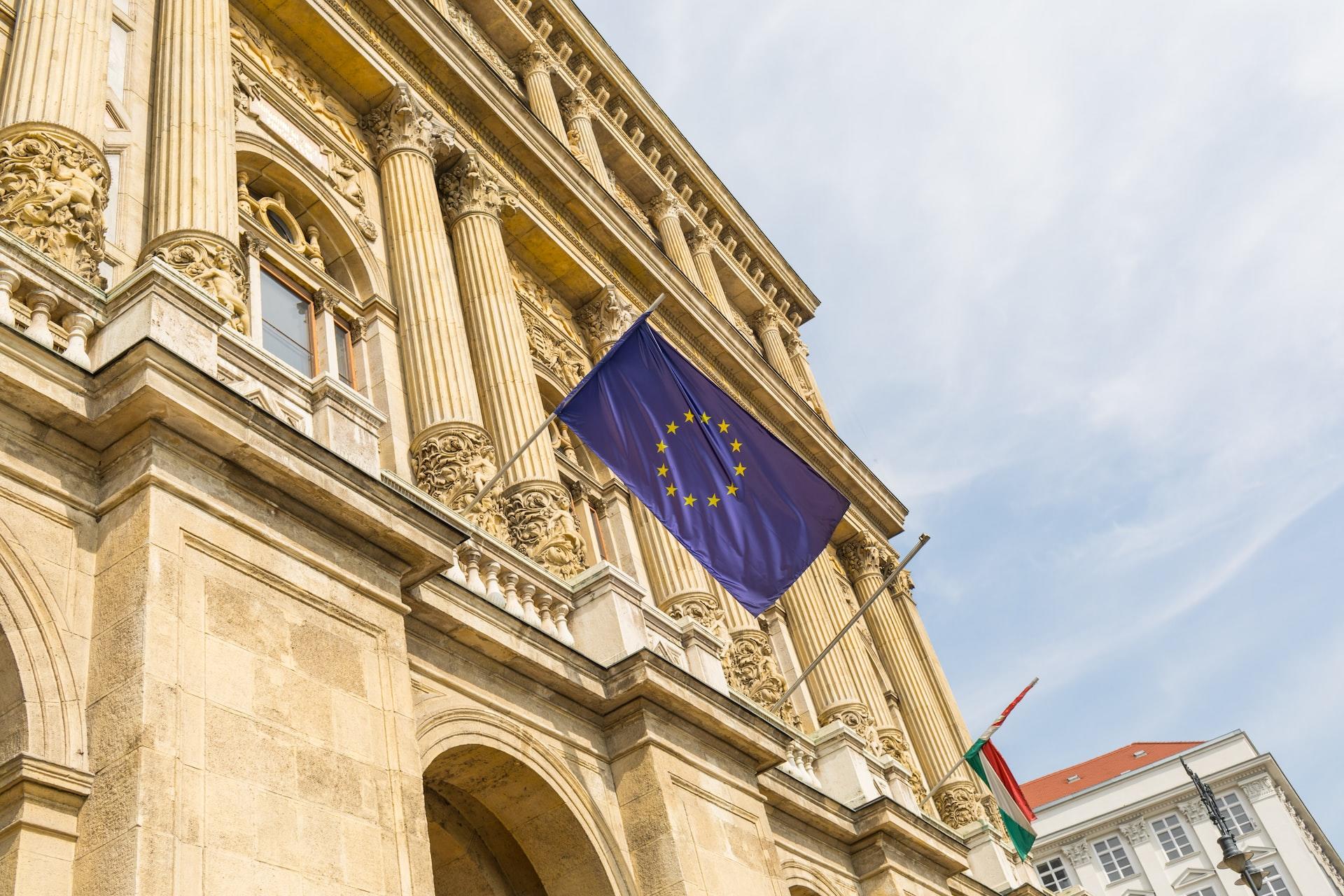 Flaggen der EU und Italiens an einer Fassade eines alten Gebaeudes stehen für das Friedensprojekt Europaeische Union.