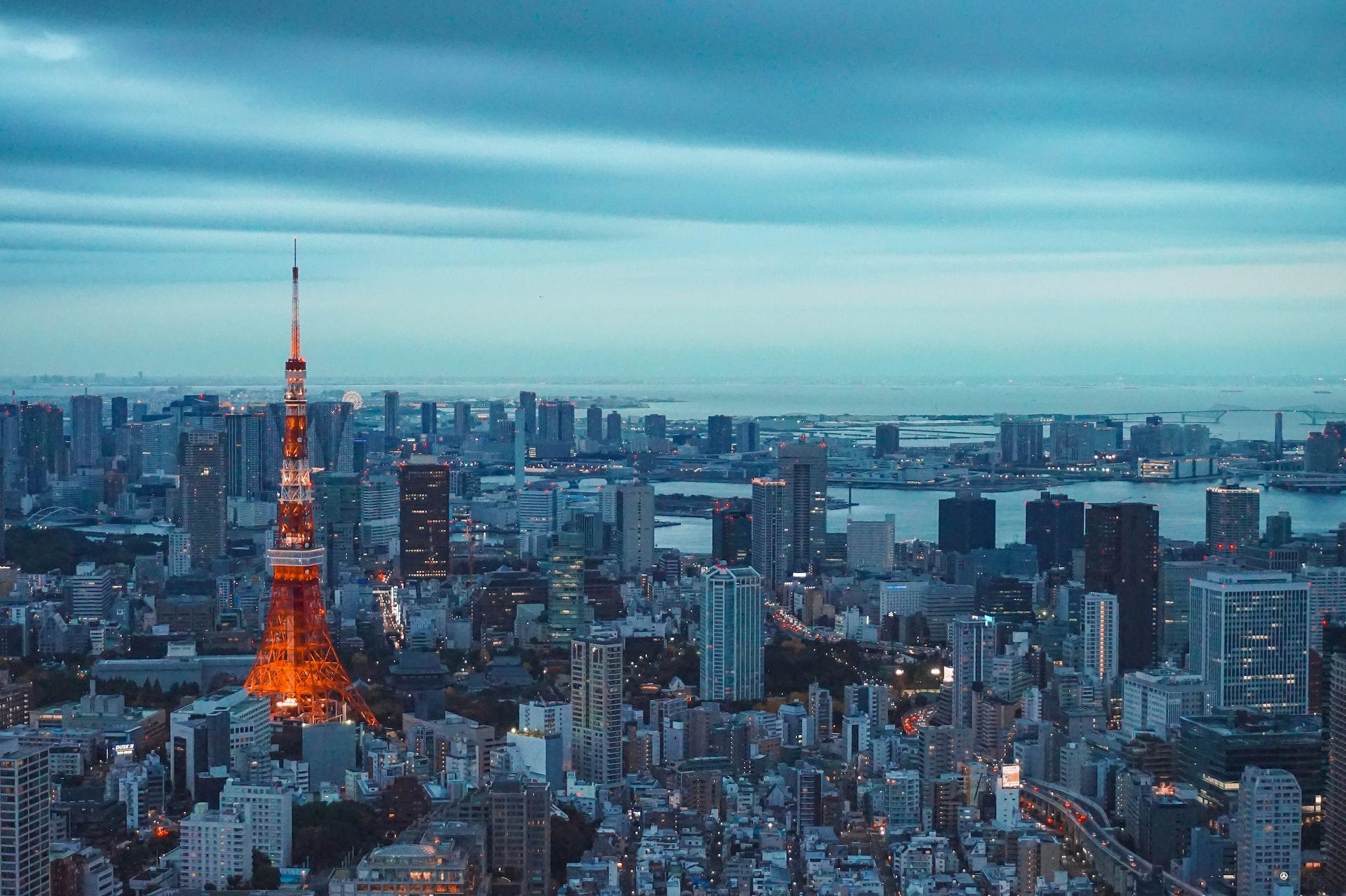 In der Dämmerung ist der Tokyotower rötlich beleuchtet und sticht aus der Skyline heraus.