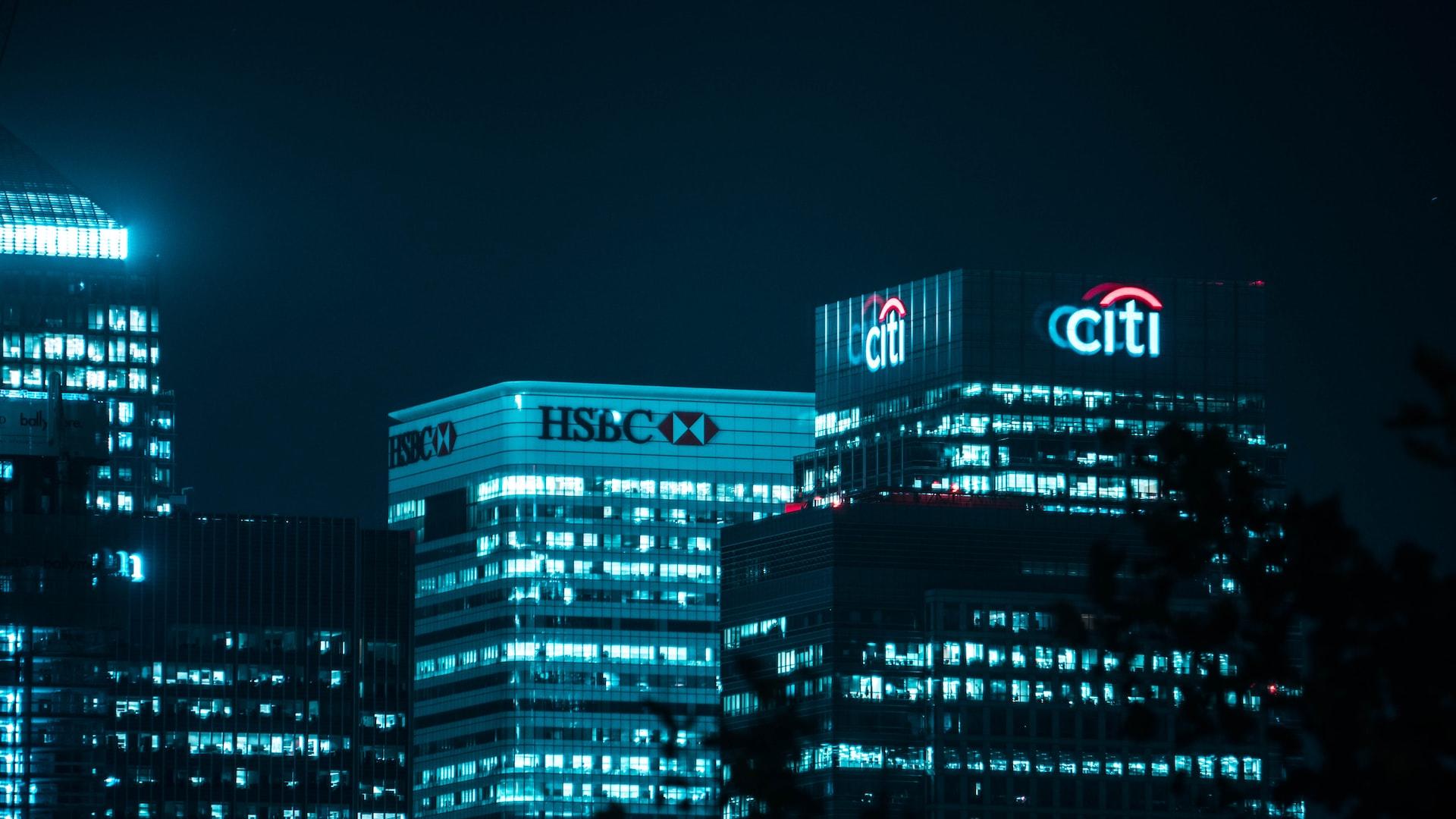 Drei Gebäude mit Neonschildern bei Nacht.