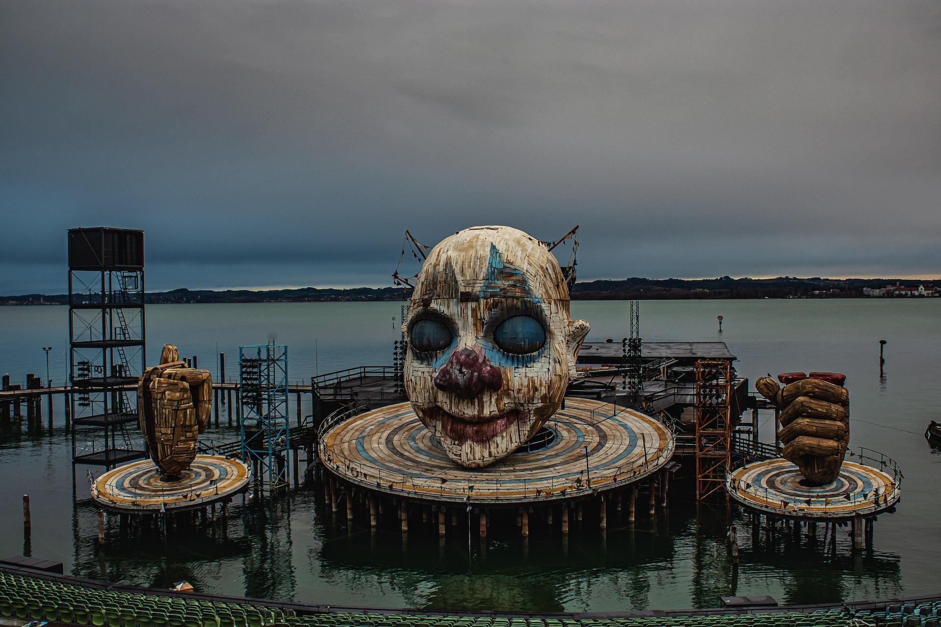 Die Kulisse der Seespiele Bregenz mit einem großen Clownskopf auf einer Scheibe im Wasser stehen für Opernerlebnisse.