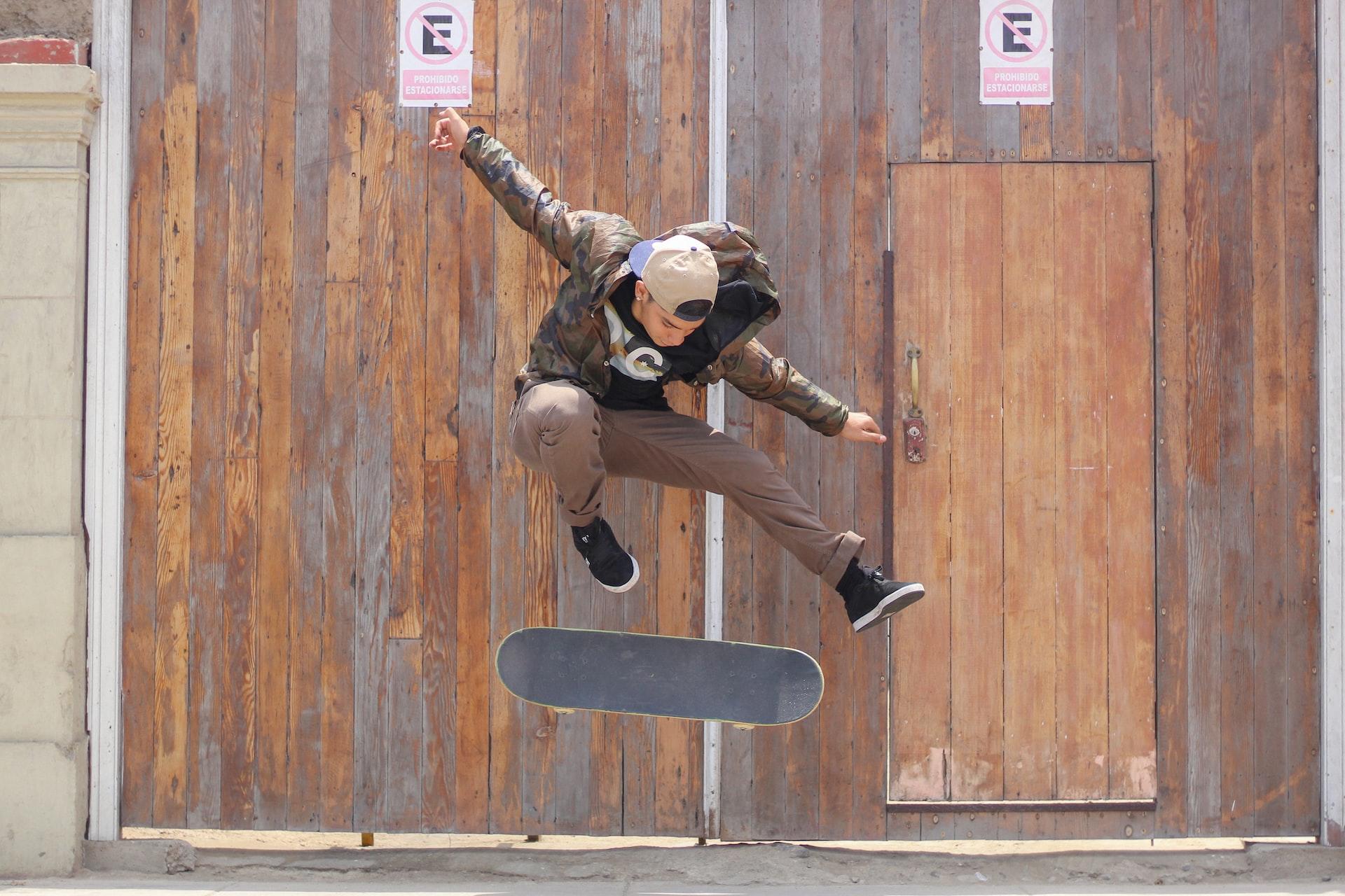 Eine Person springt mit einem Skateboard in die Luft und macht eine Pose.