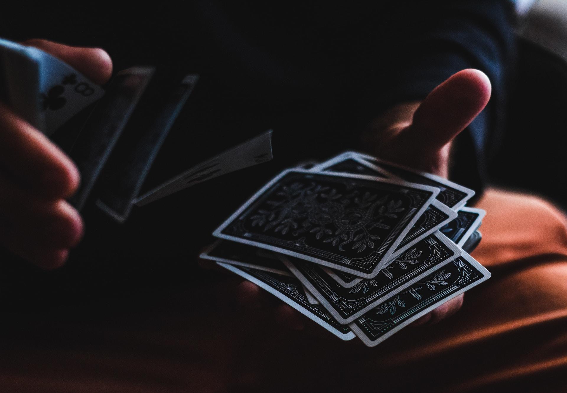 Zwei Händen halten Spielkarten und mischen sie.