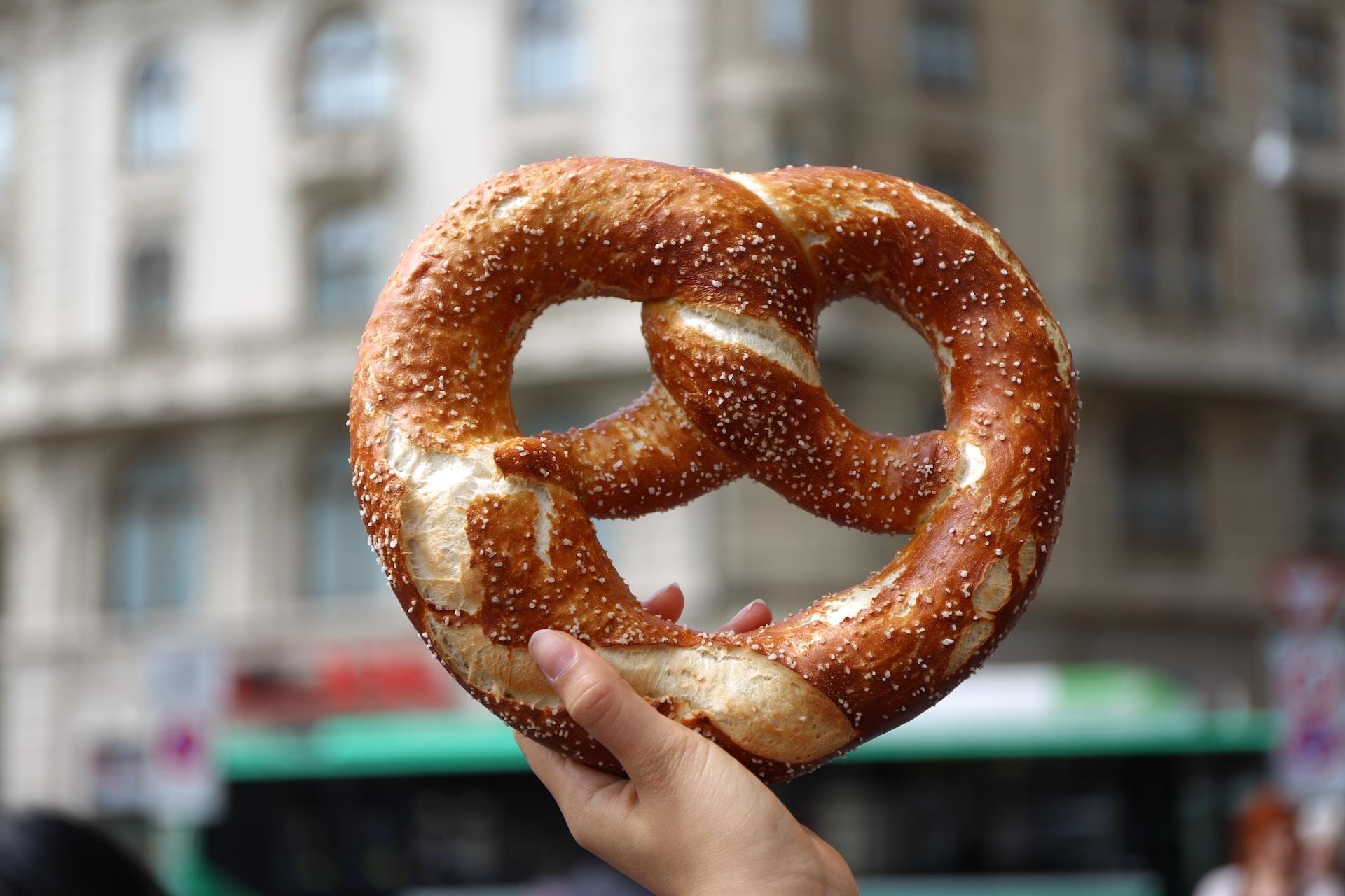 Eine Brezel wird von einer Hand gehalten