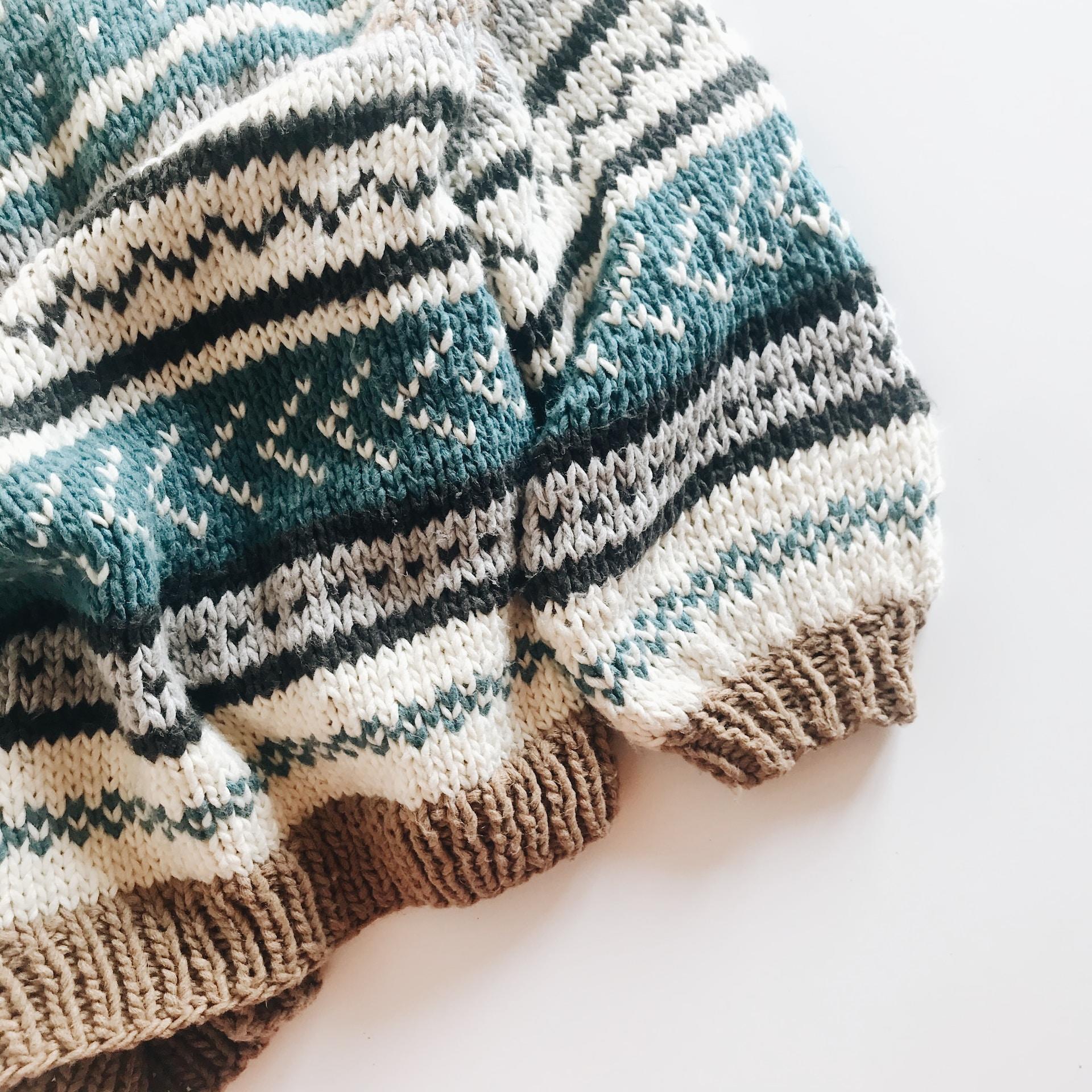 Gestrickter Pulli in grün braun und weiß.