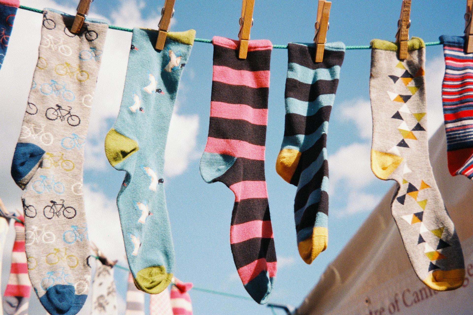 Bunte Socken an einer Wäscheleine hängend.