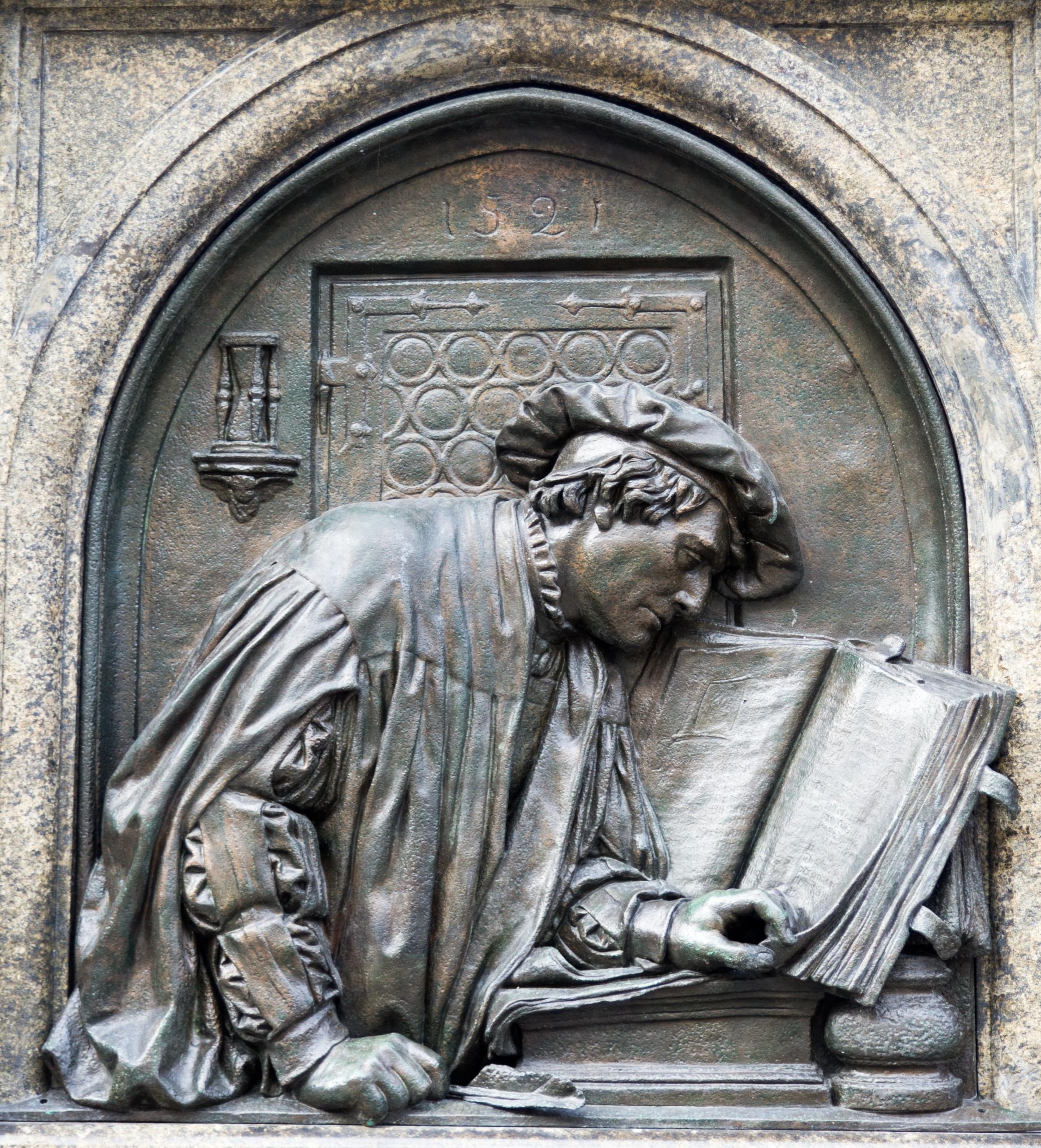 Ein Denkmal zeigt Martin Luther mit einem großen Buch.