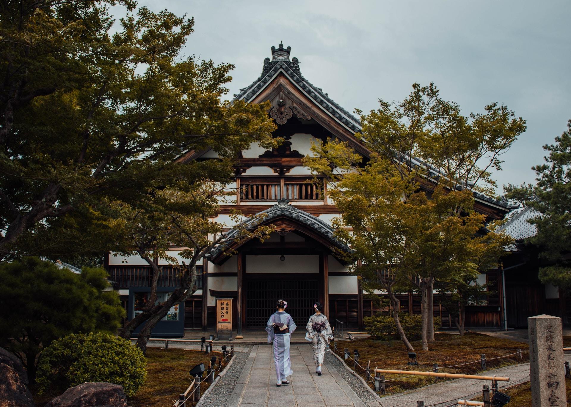 Zwei Geshas vor einem japanischen Tempel.