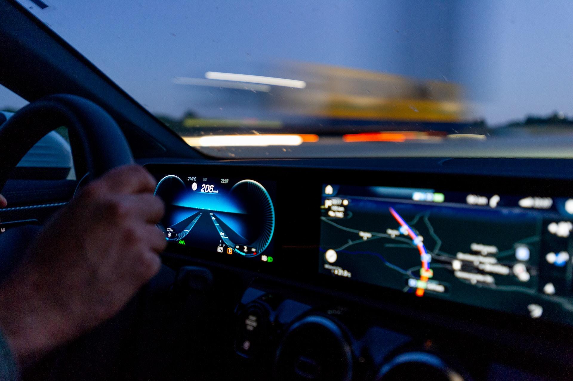Innenraum eines Autos mit Händen am Steuer.