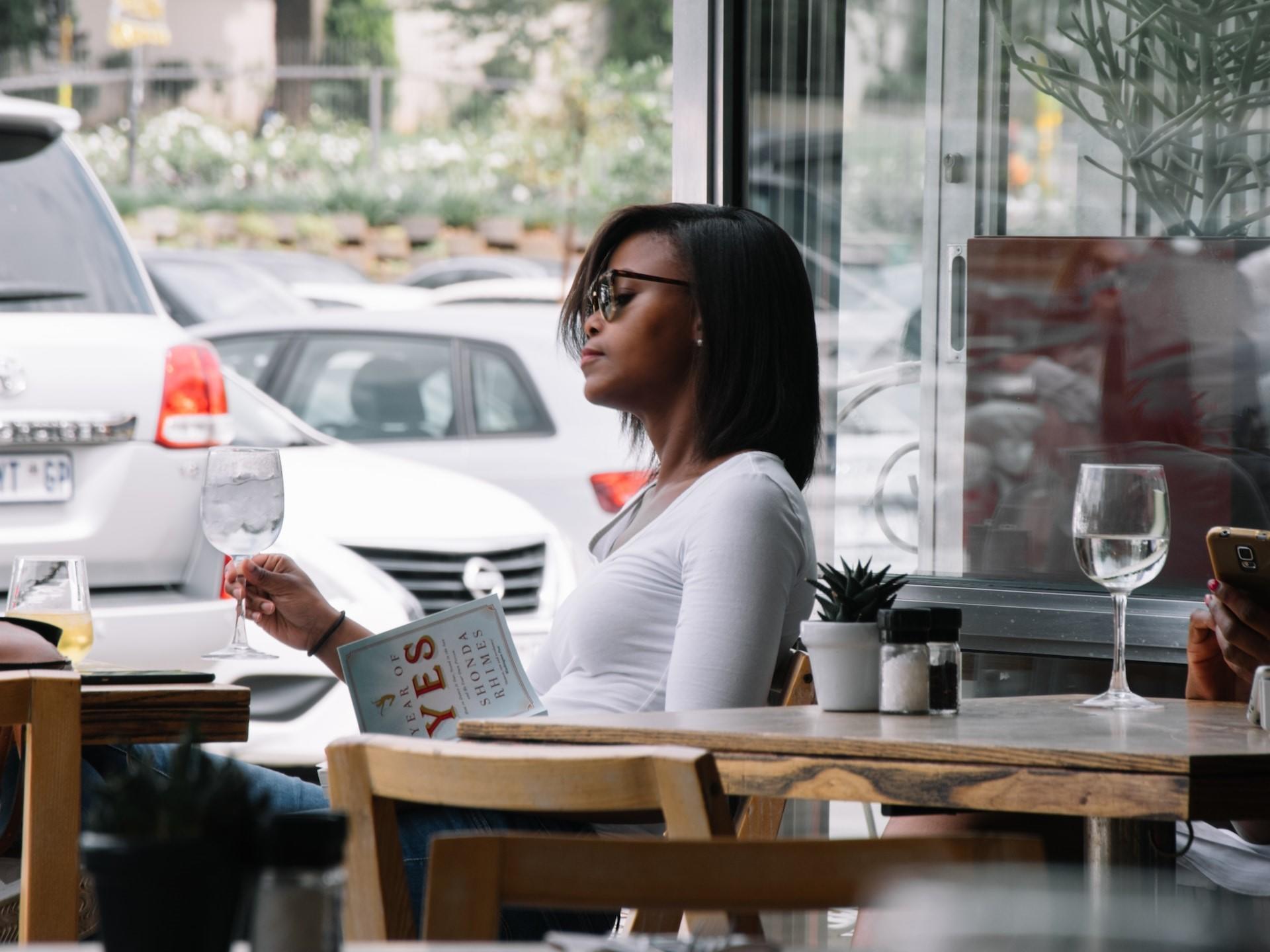 Frau im Restaurant mit Glas Wasser in der Hand