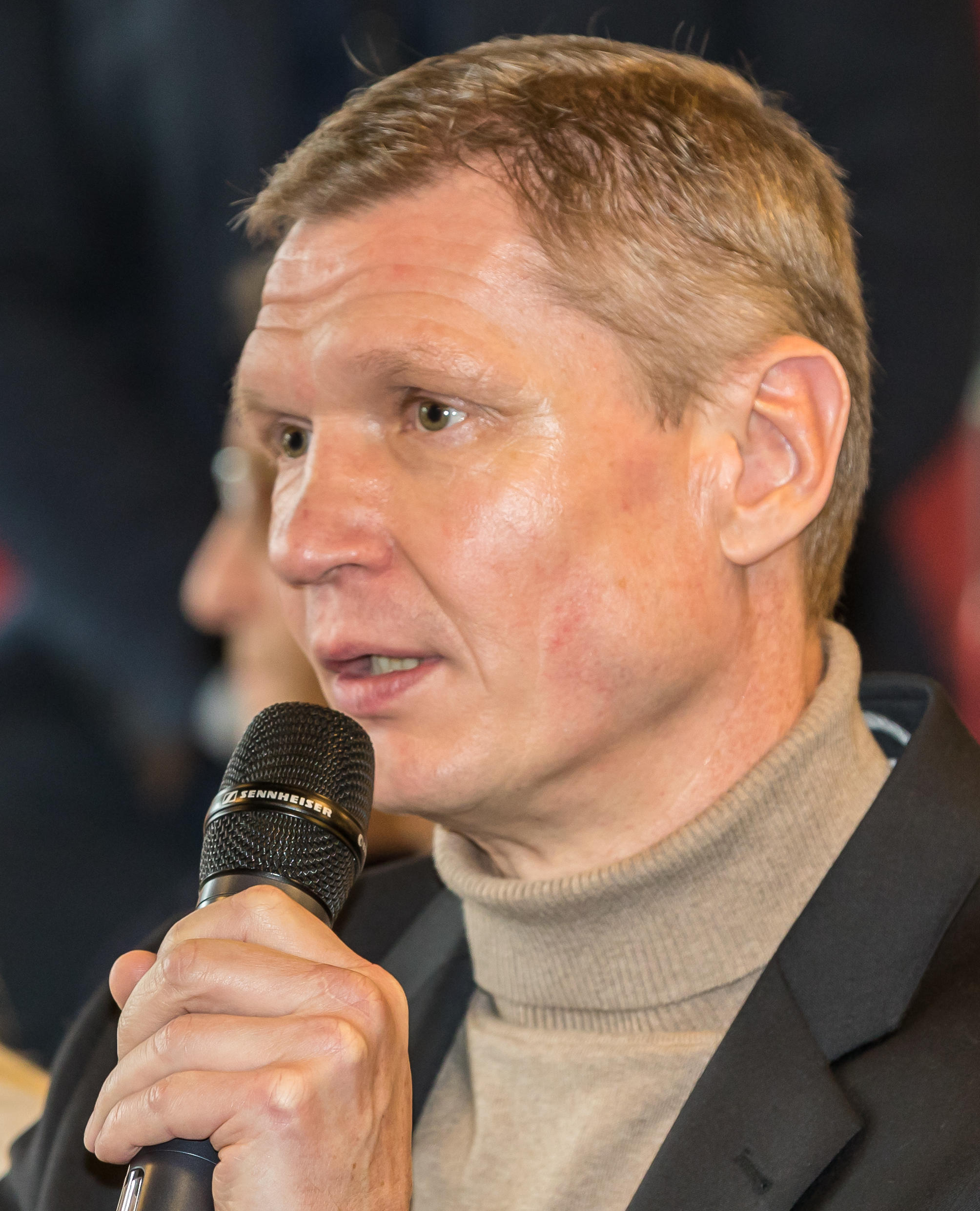 Torsten May in Nahaufnahme mit einem Mikrofon in der Hand.
