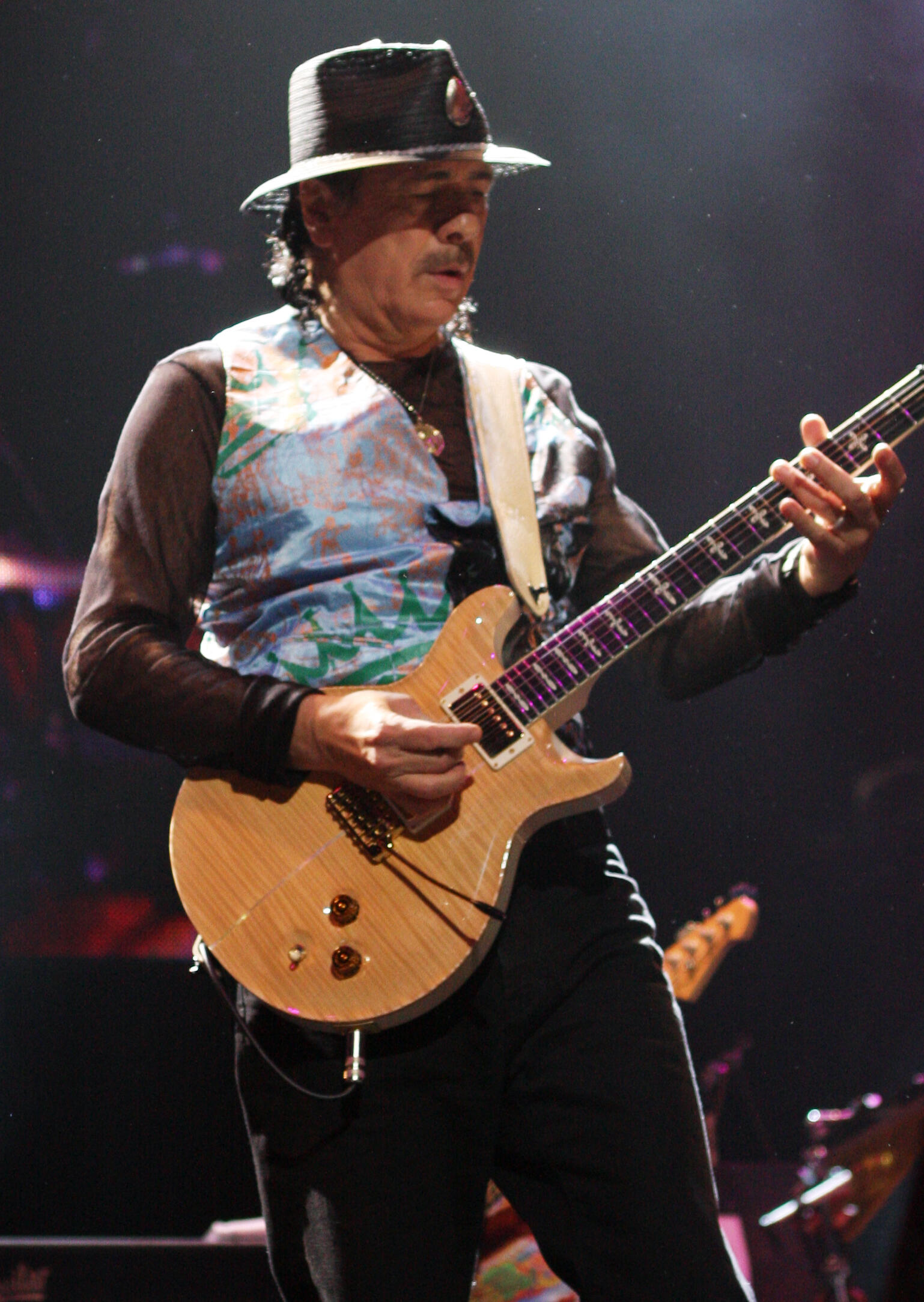 Carlos Santana mit Hut und Gitarre auf einer Bühne