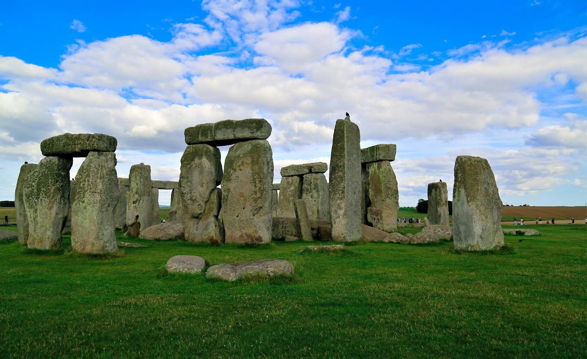 Stonehenge auf grüner Wiese vor blauem Himmel