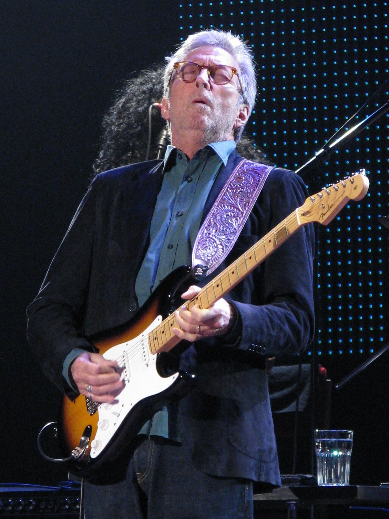 Fotografie von Eric Clapton auf der Bühne beim Gitarre spielen