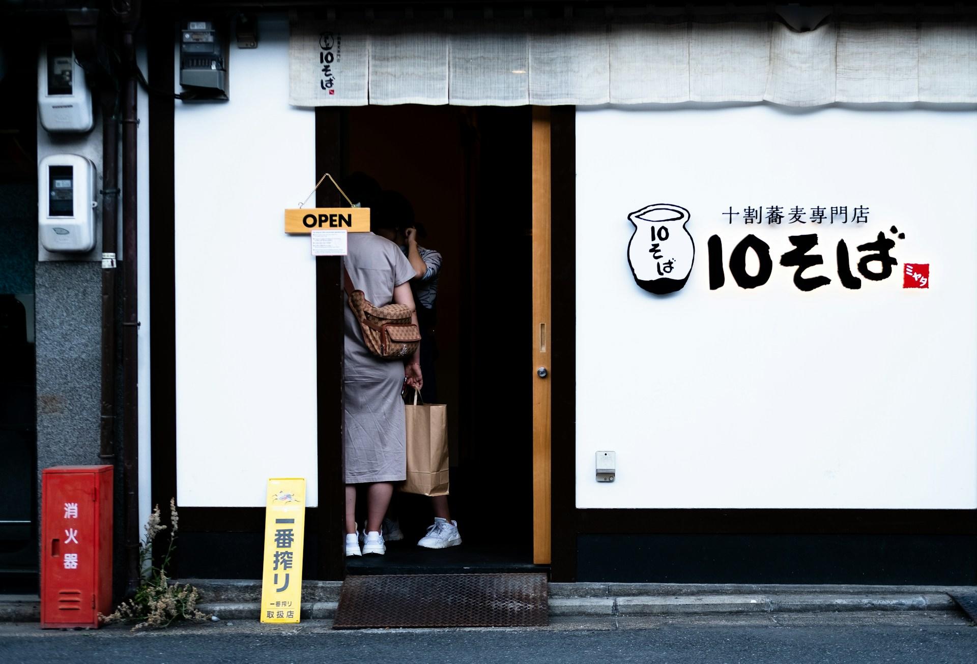 Eingang eines Restaurants mit zwei Personen in der Tür.