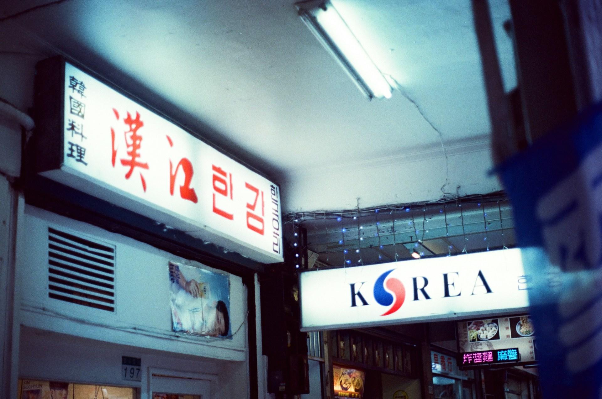 Leuchtreklame an Wand mit koreanischer Schrift.