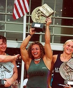 Die Bodybuilderin Jill Mills hält einen Pokal in die Höhe