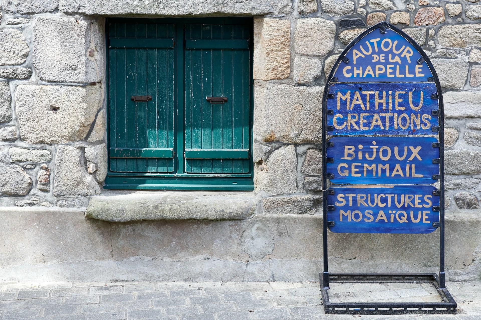 Wand mit grünem Fenster und Plakat davor.