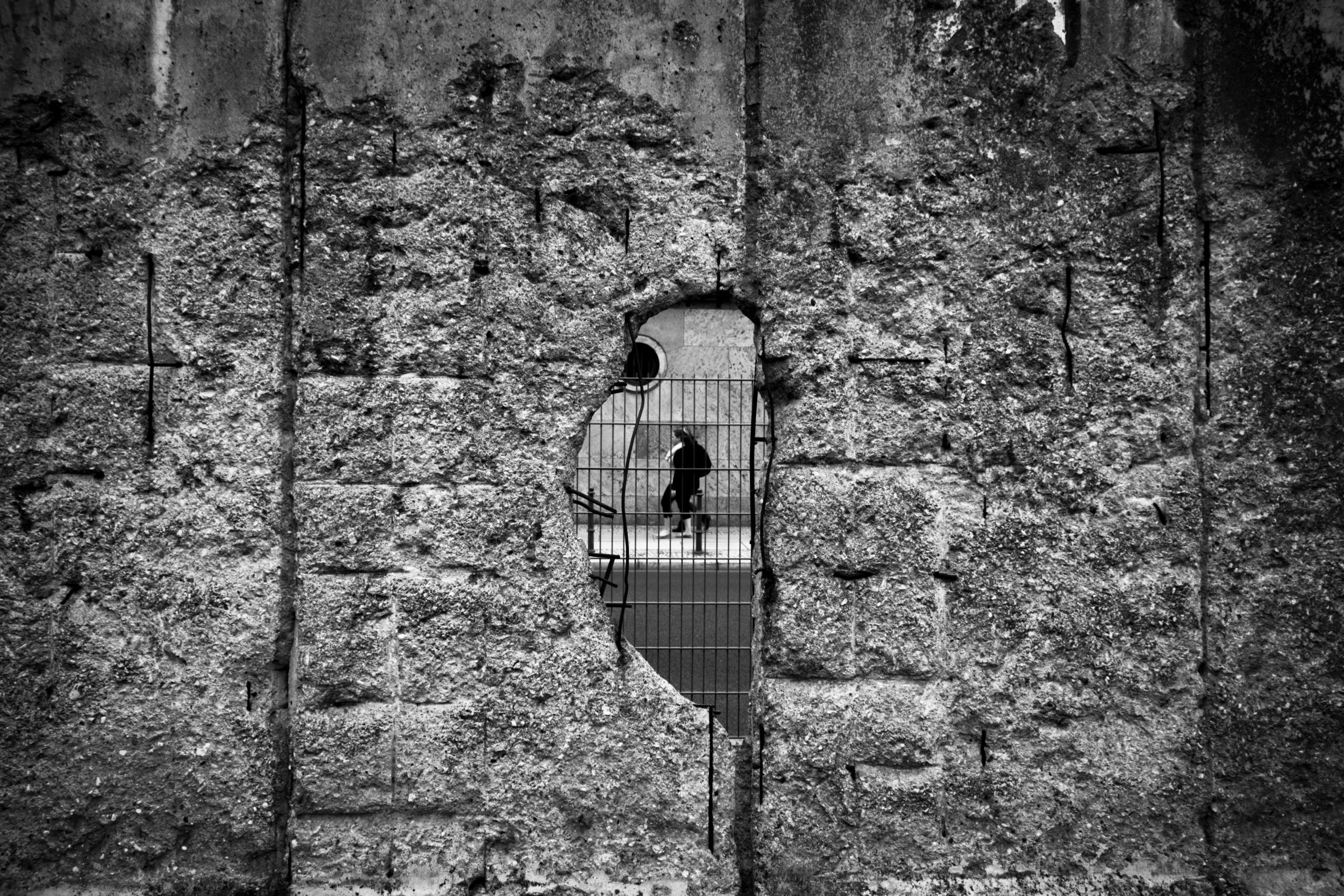 Man schaut durch ein Loch in der Berliner Mauer