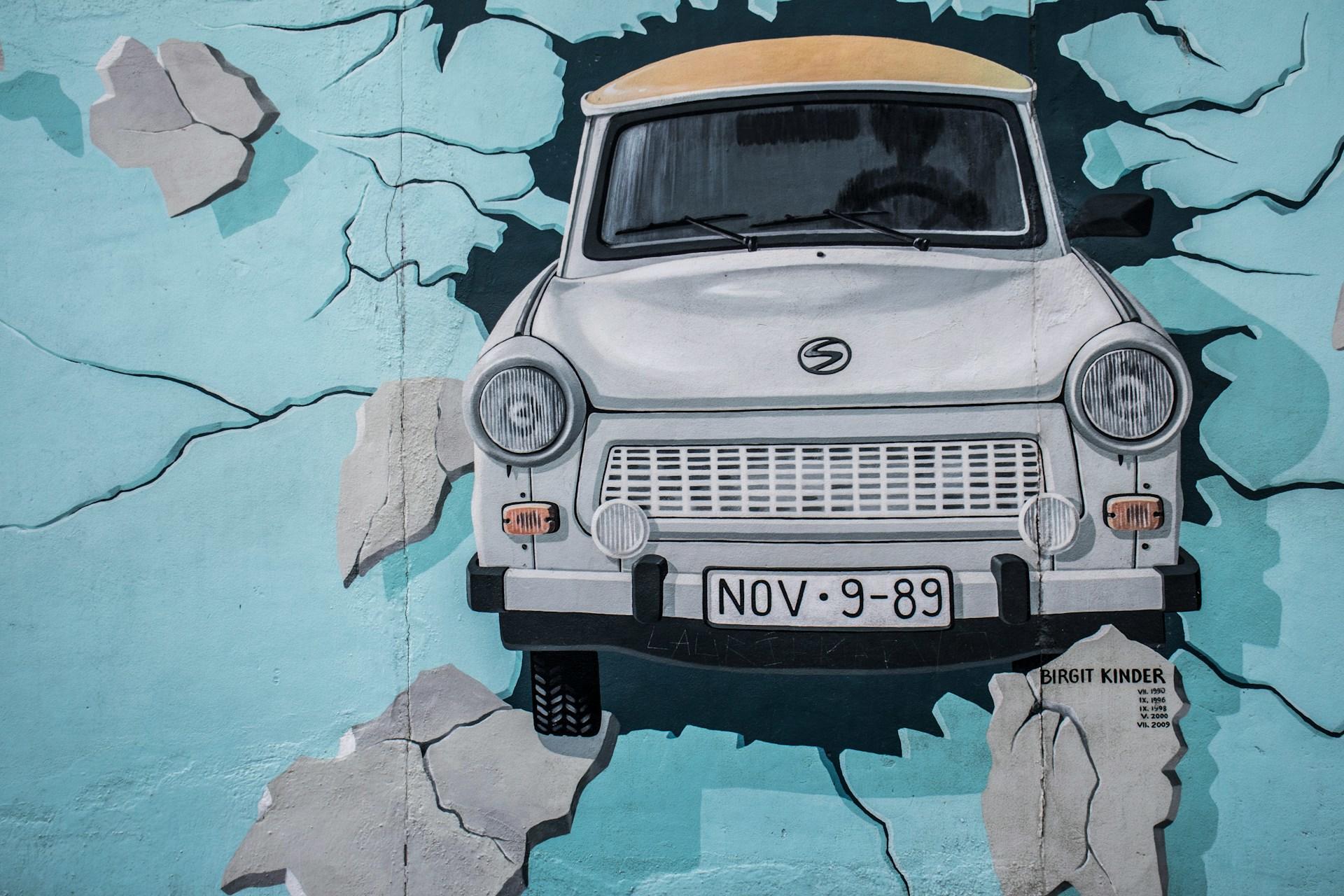 Bild eines Trabis auf der Berliner Mauer
