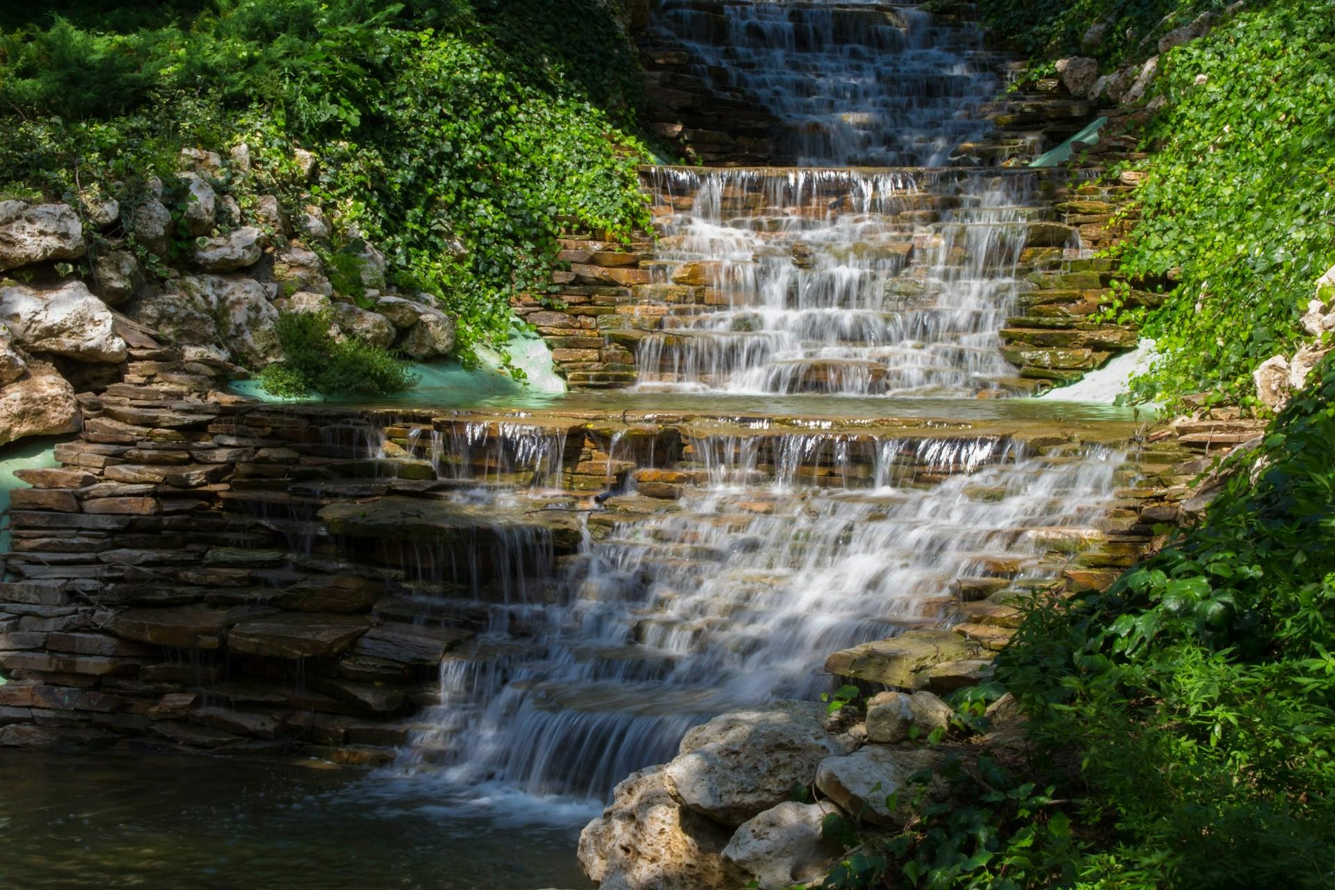 ein Wasserfall umgeben von grünen Pflanzen
