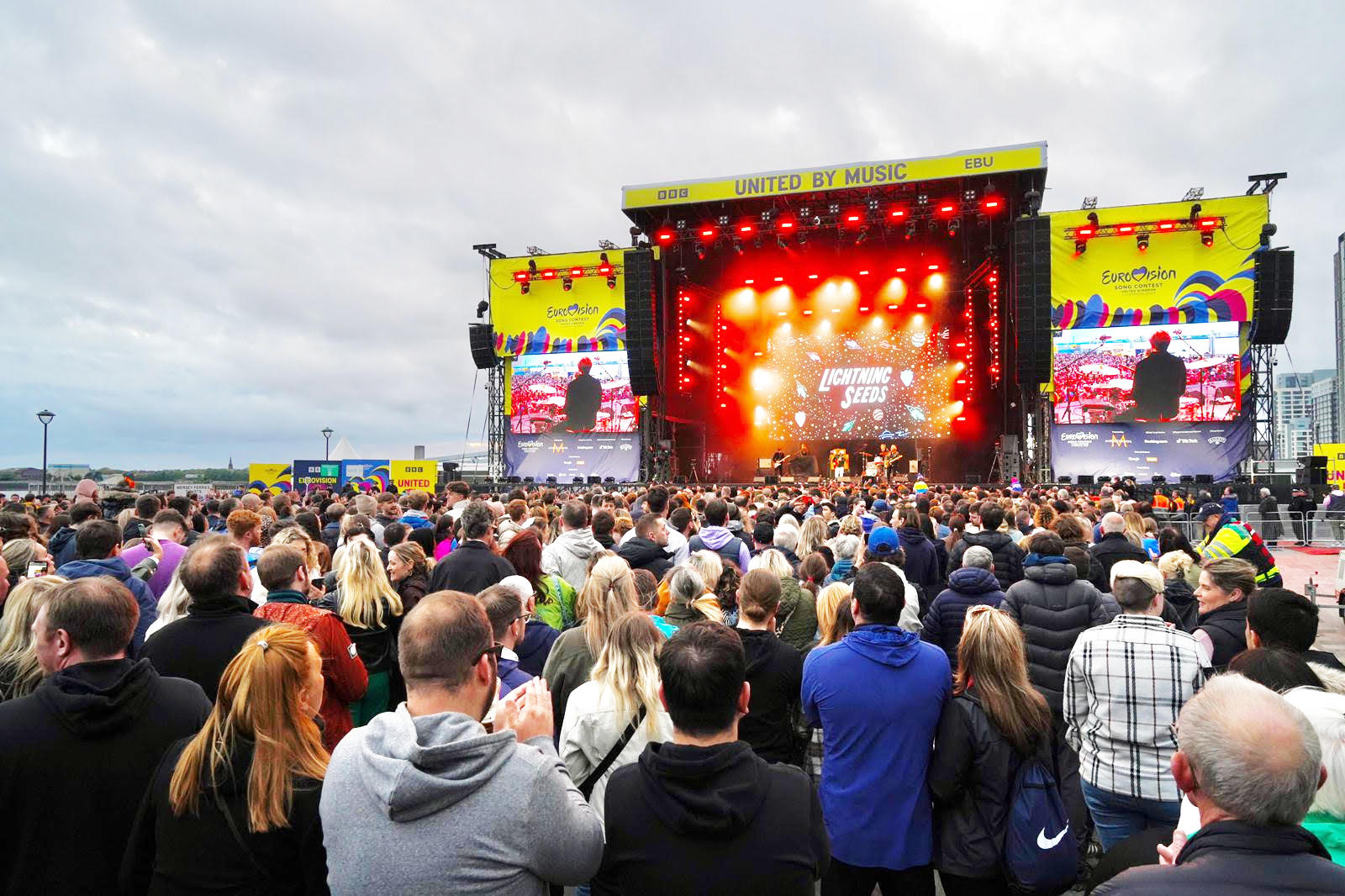 Eine Freiluftbühne mit ESC Bannern, Licht und vielen Fans