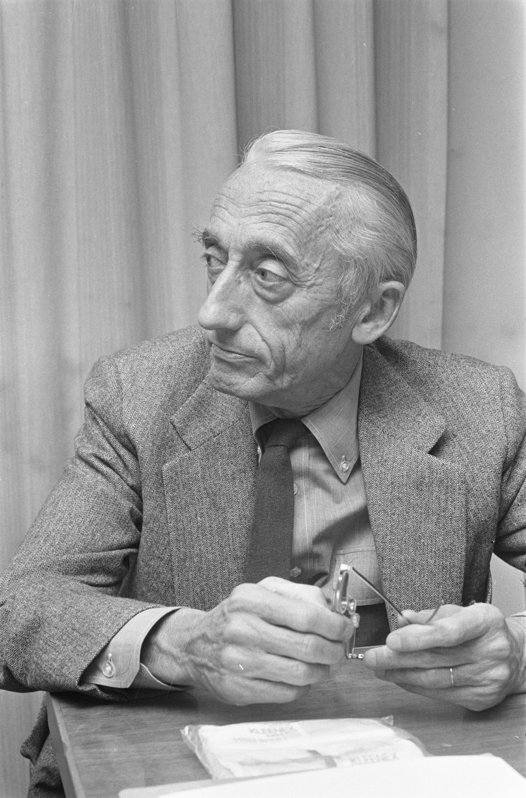 Jacques-Yves Cousteau sitzt an einem Tisch