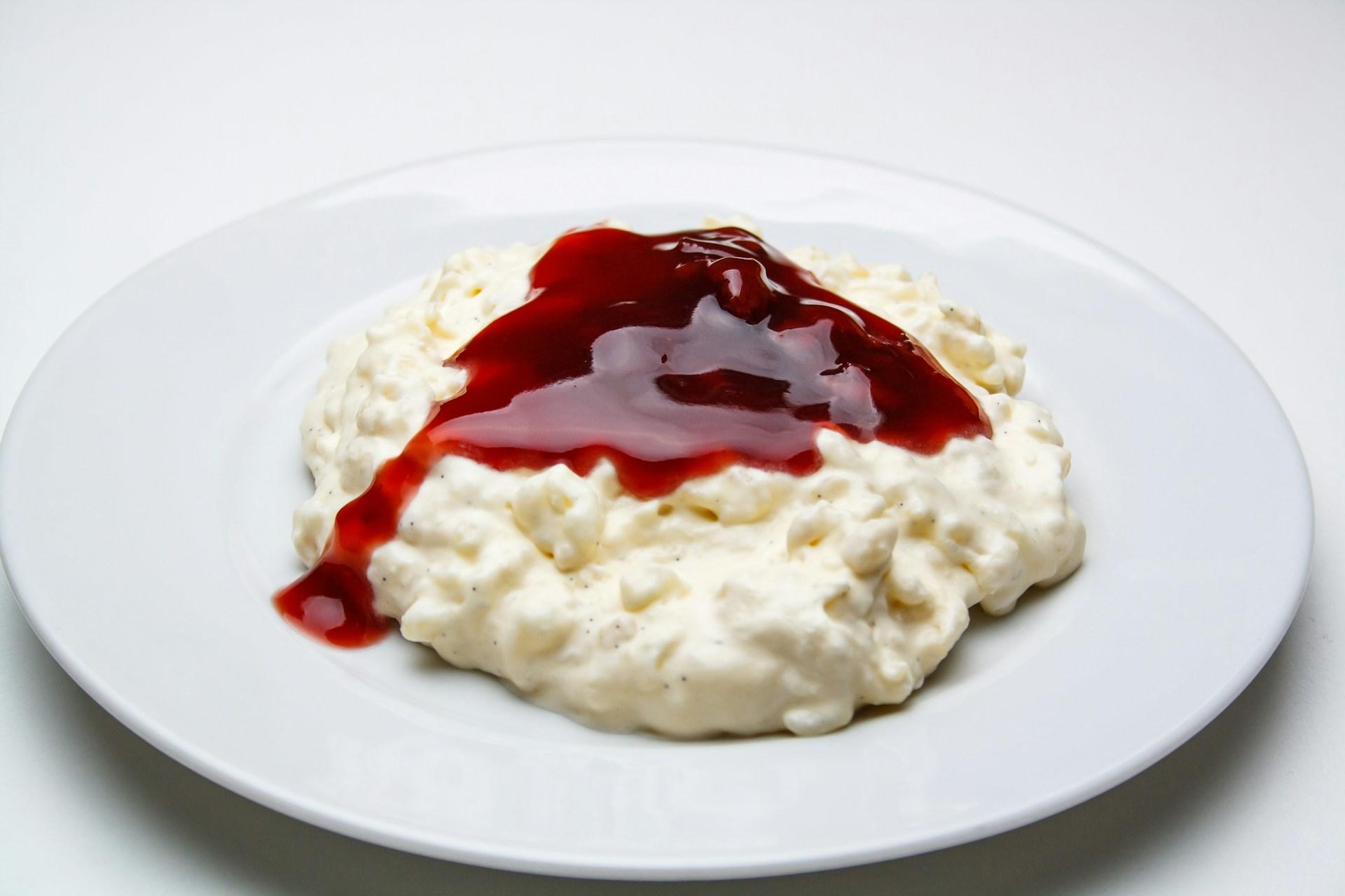 Milchreis mit roter Sauce auf Teller.